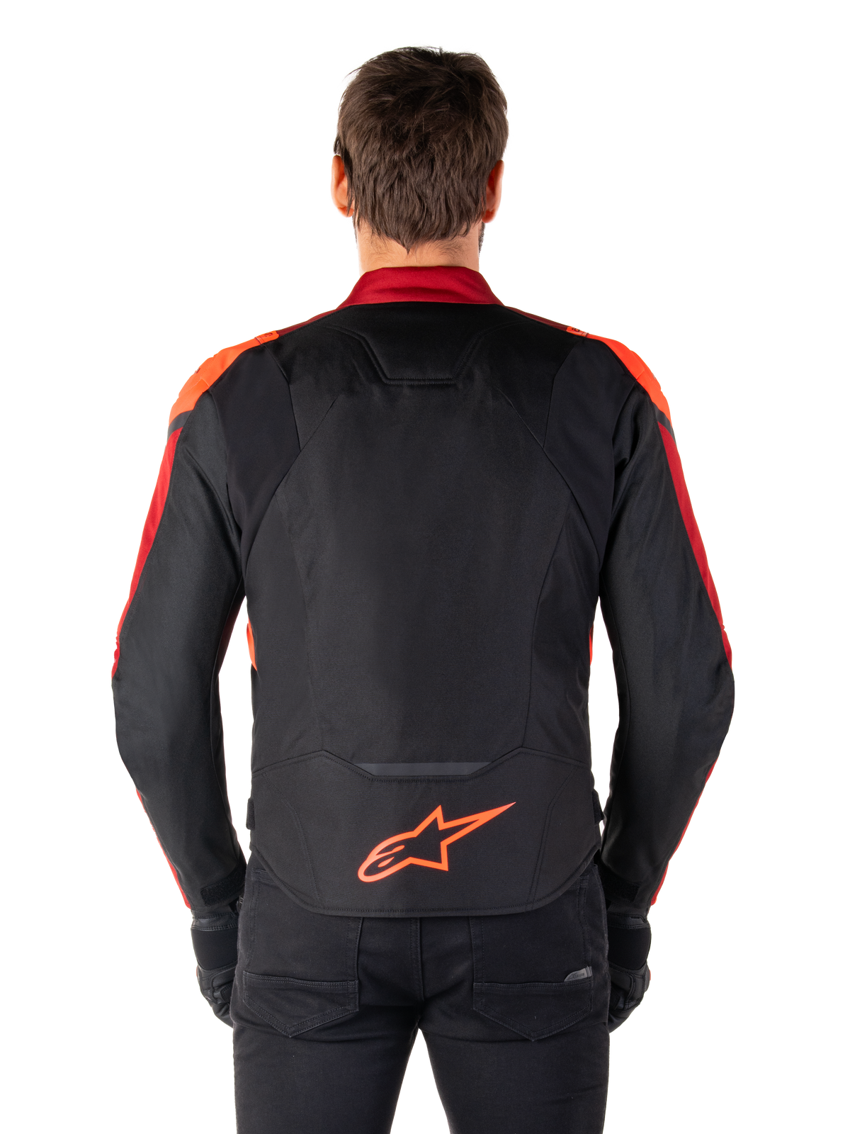 Alpinestars T-Jaws V4 Wasserdichte Jacke, Rückansicht, Schwarz mit Red Fluo und dunkelroten Akzenten, orangefarbenes Logo am unteren Rücken, verlängerte Rückenpartie für bessere Abdeckung beim Fahren, sportliche Textil-Motorradjacke