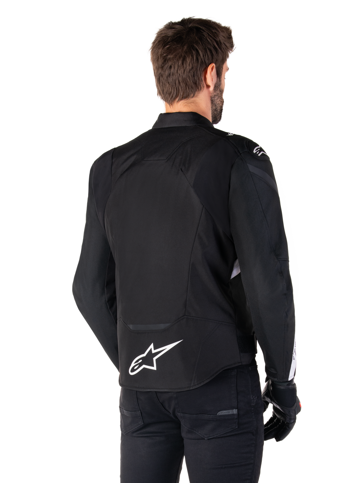 Alpinestars T-Jaws V4 Waterproof Jacket, Black and White, rear view, textile sport motorcycle jacket with white logo on the lower back, worn with black gloves and pants, featuring a revised sport fit silhouette