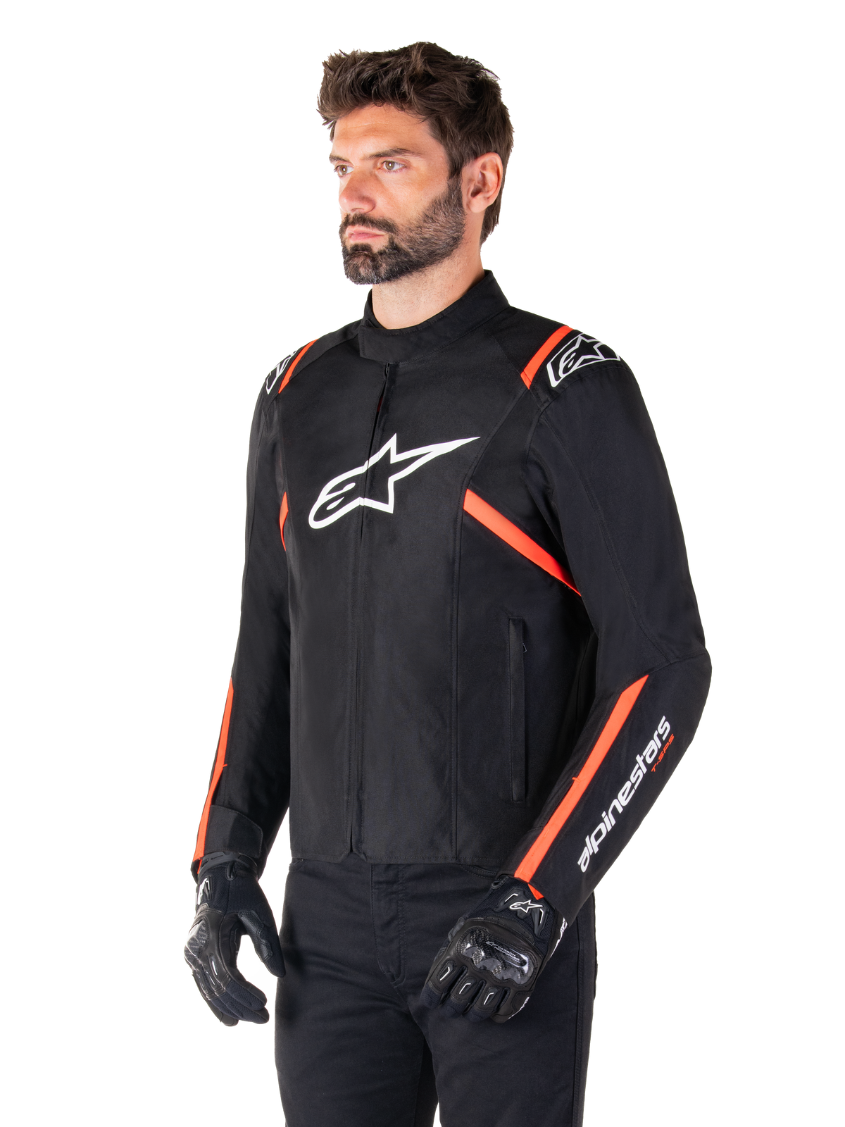 Alpinestars T-SPS V2 Waterproof Jacke, Schwarz, Weiß und Rot Fluo, getragen von einem männlichen Model mit schwarzen Handschuhen und Hosen, weißes Alpinestars-Logo auf der Brust, leuchtend rote Akzente an den Schultern und Ärmeln, sportliches Textildesign