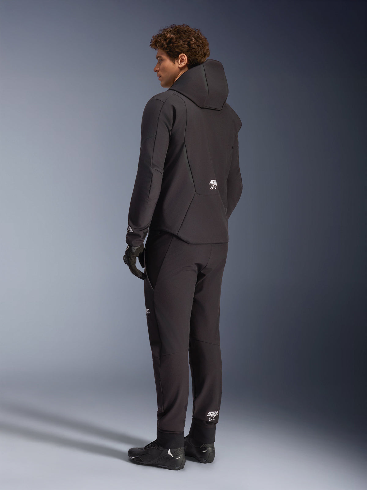 Alpinestars Aeroshell waterdichte jas, zwarte herenmotorhoodie van softshell, achteraanzicht op model.