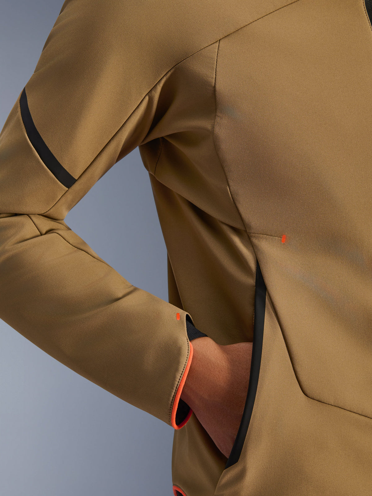 Close-up van de Alpinestars Aeroshell waterdichte jas, Dark Khaki met zwarte en fluo oranje accenten, detail van de verborgen handzak met rits en de mouwboord, stretch softshell textiel voor motorrijden