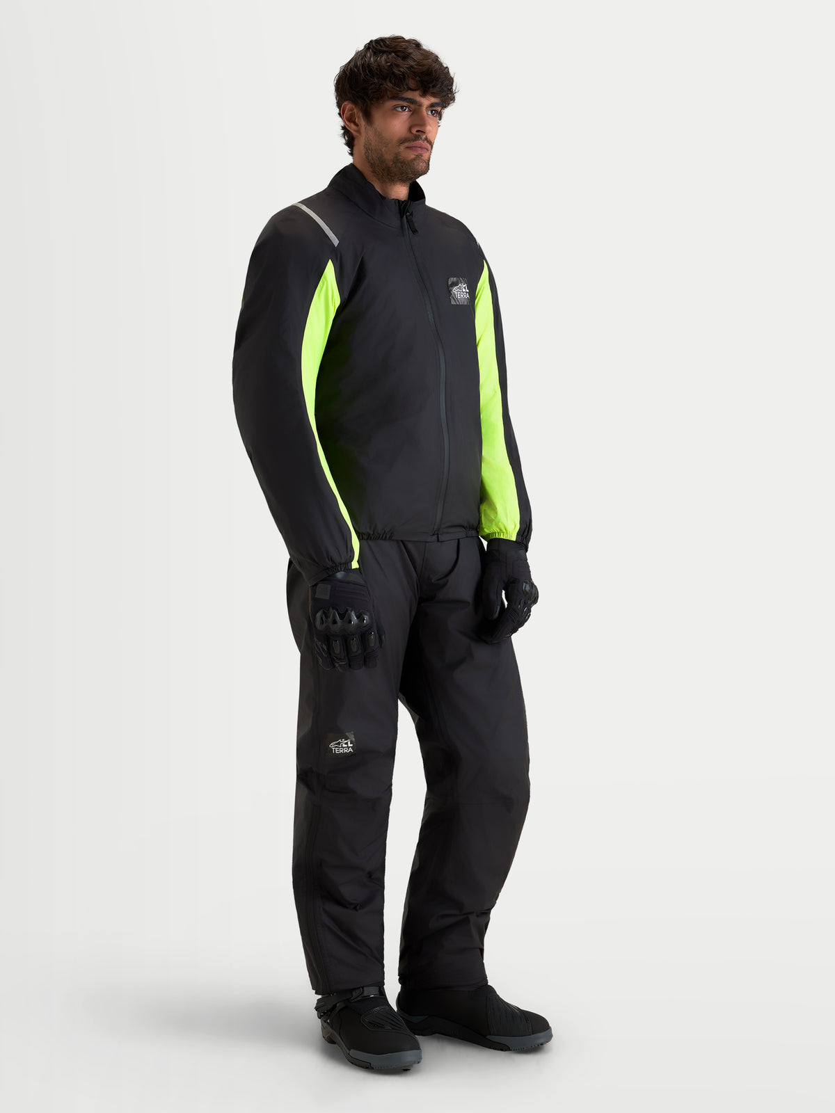 Alpinestars Harok V 2 Drystar Jacke, Herren-Abenteuer-Motorradjacke in Schwarz und Leuchtgelb, getragen mit passender Fahrerausrüstung bei einer Produktaufnahme am Model