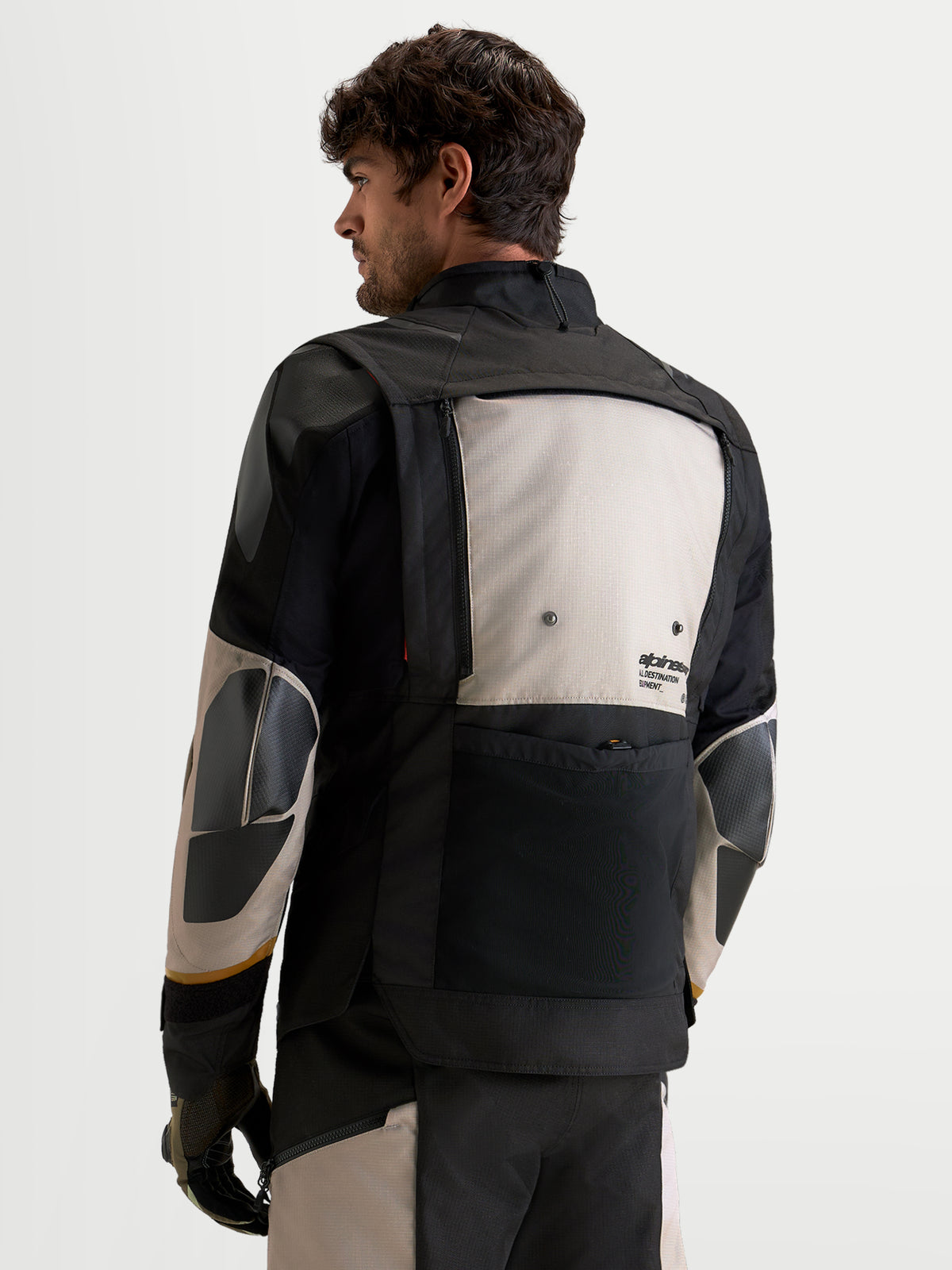 Alpinestars Harok V2 Drystar, veste de moto d'aventure pour homme, gris aluminium, marron et noir, vue de dos montrant la construction textile et les panneaux de ventilation modulaires