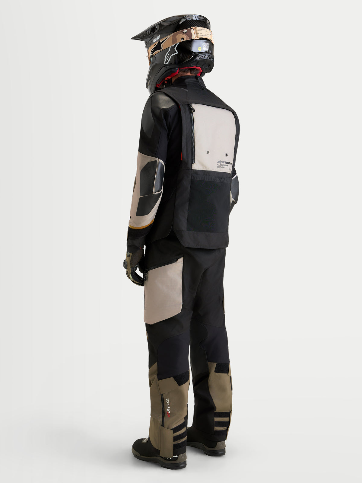 Alpinestars Tenue complète Harok V2 Drystar, tenue de moto adventure pour homme en noir et khaki, vue de dos sur un modèle portant l'équipement assorti et un casque, vêtement d'équitation imperméable pour toutes les conditions météorologiques