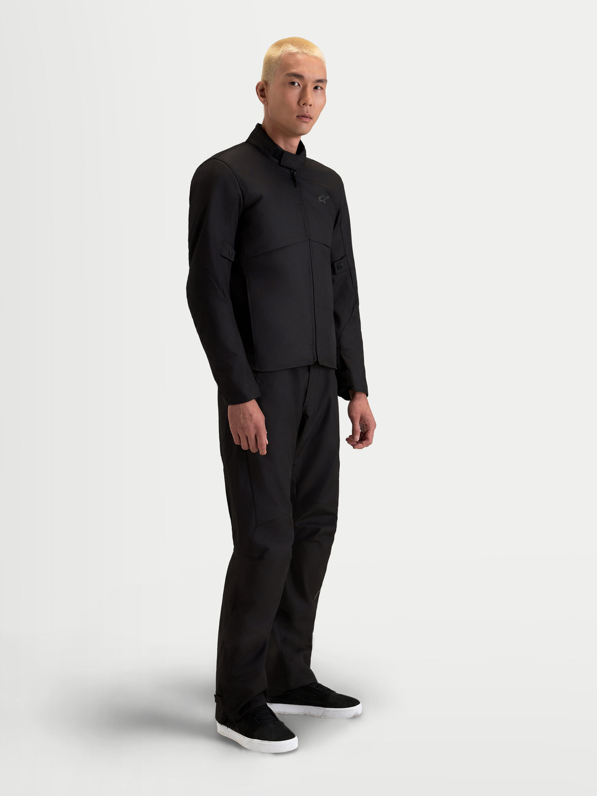 Alpinestars C-1 Waterproof Jacket, men's urban contemporary motorcycle textile jacket in black, side view on a model wearing matching trousers, featuring waterproof polyfabric construction and soft-finish collar.