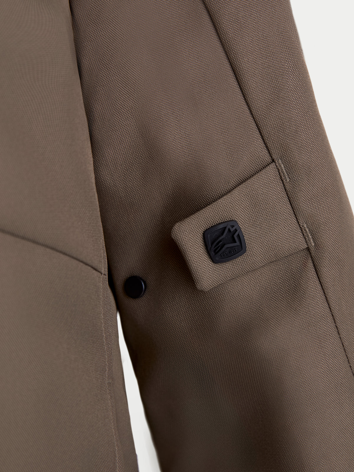 Alpinestars C-1 Waterproof Veste, veste de moto urbaine en textile, vue de détail marron noyer montrant la construction en polyfabric 450D, le système de réglage par bouton-pression et le badge logo Alpinestars noir