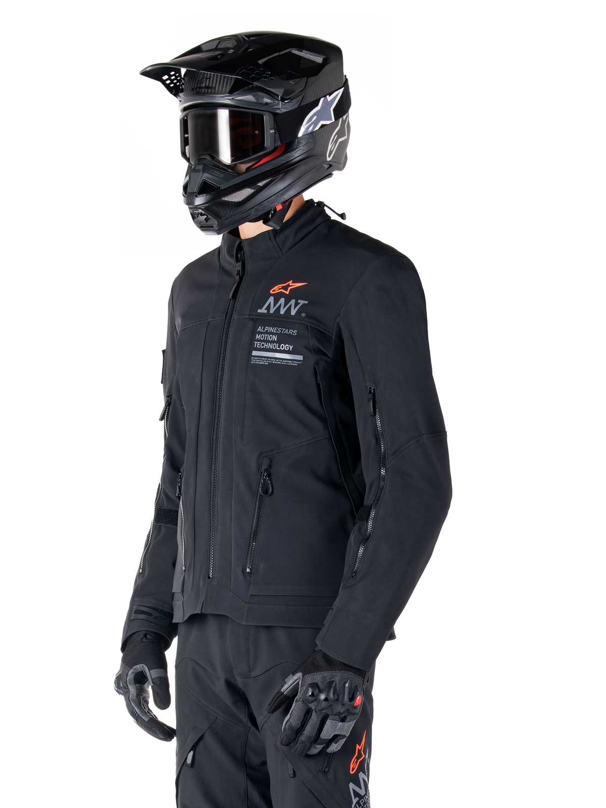 Alpinestars AMT-8 Stretch Drystar® XF Jacke, Schwarz, getragen von einem Fahrer mit passender Adventure-Hose und Handschuhen, mit einem schwarzen Motocross-Helm und einer Schutzbrille, Belüftungsöffnungen mit Reißverschluss an Brust und Armen, Alpinestars Motion Technology-Branding mit einem orangefarbenen Logo, Premium-Adventure-Touring-Ausrüstung.