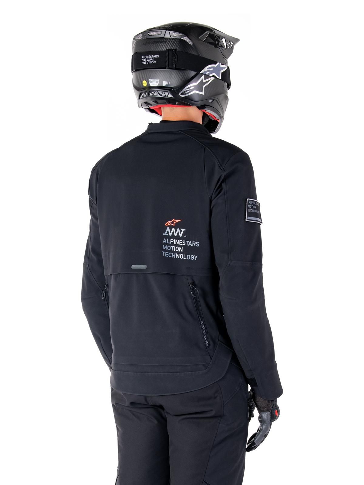 Rückansicht eines Fahrers in der Alpinestars AMT-8 Stretch Drystar® XF Jacke in Schwarz, mit 'AMT Alpinestars Motion Technology' Branding auf dem Rücken, technischen Belüftungsreißverschlüssen, kombiniert mit einem schwarzen Motorradhelm und Handschuhen