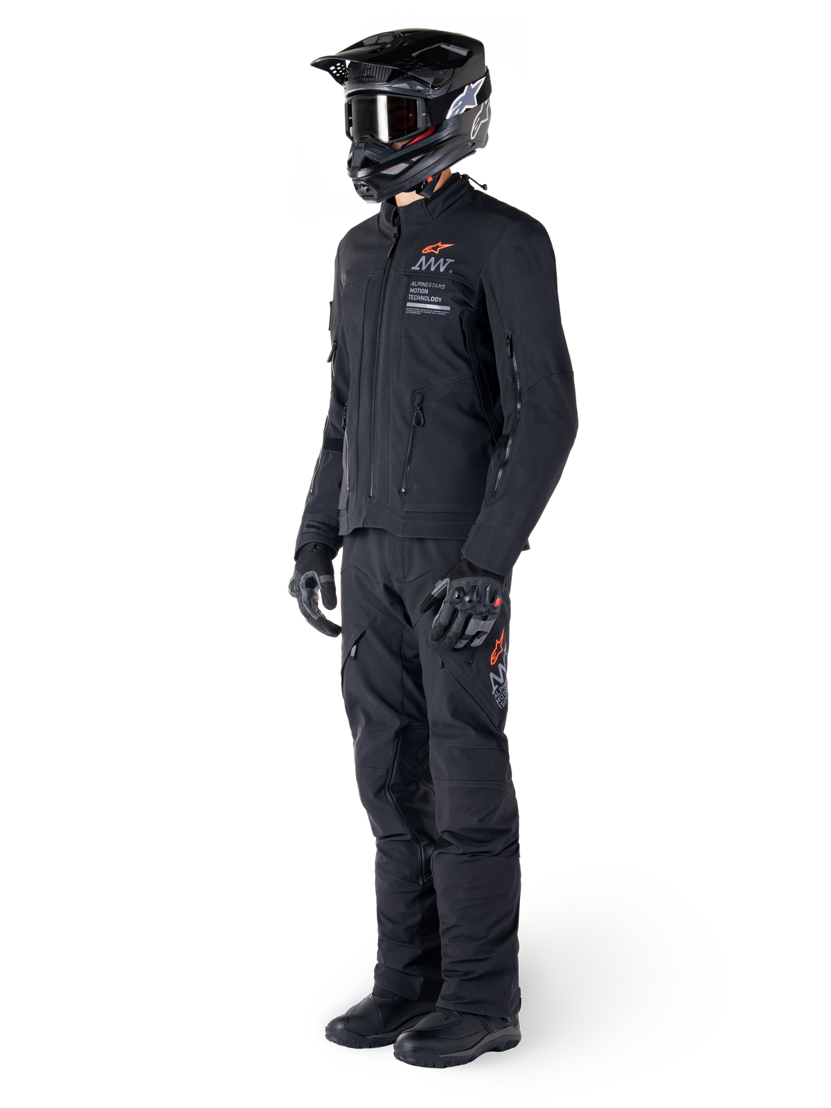Alpinestars AMT-8 Stretch Drystar® XF Jacke, Adventure-Motorradjacke, Schwarz, getragen mit passender Hose, Helm und Handschuhen, mit Alpinestars Motion Technology Branding und orangefarbenen Akzenten, strapazierfähige Stretch-Konstruktion für Adventure-Touren