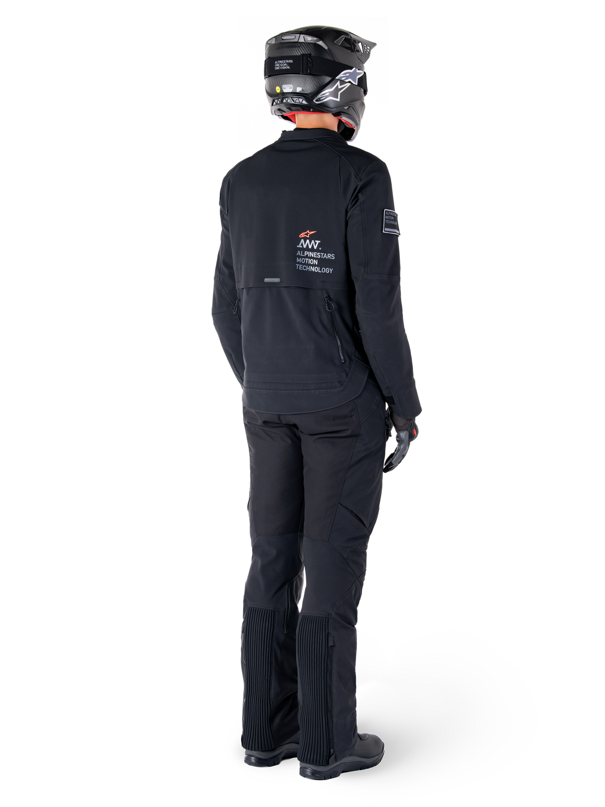 Alpinestars AMT-8 Stretch Drystar® XF Jacke, Schwarz, Rückansicht eines Fahrers mit passender schwarzer Hose und schwarzem Helm, mit „Alpinestars Motion Technology“-Branding auf dem Rücken, technisches Stretchmaterial für Adventure-Motorradtouren