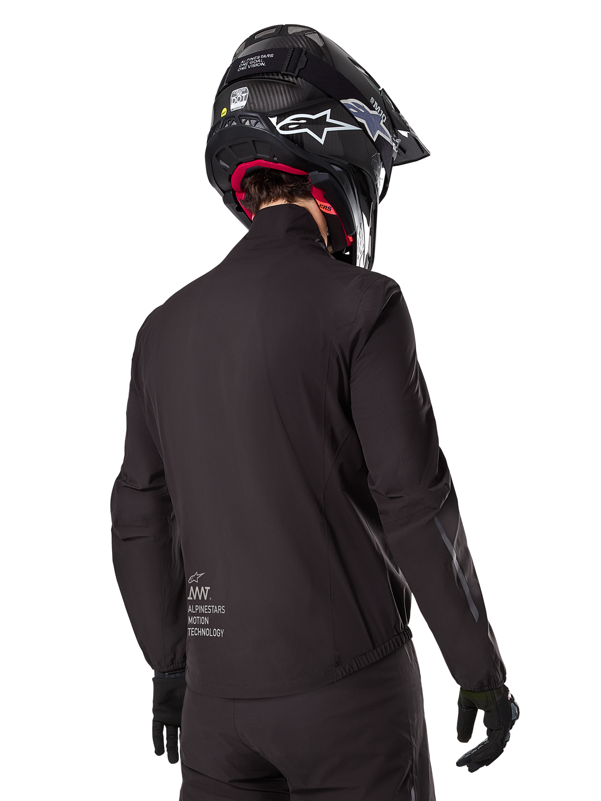 Alpinestars AMT-8 Stretch Drystar® XF Liner, schwarze wasserdichte Innenjacke, Rückansicht eines Fahrers mit schwarzem Helm und Handschuhen, mit Alpinestars Motion Technology-Branding am unteren Rücken, minimalistisches und funktionales Design für Adventure-Fahrten.
