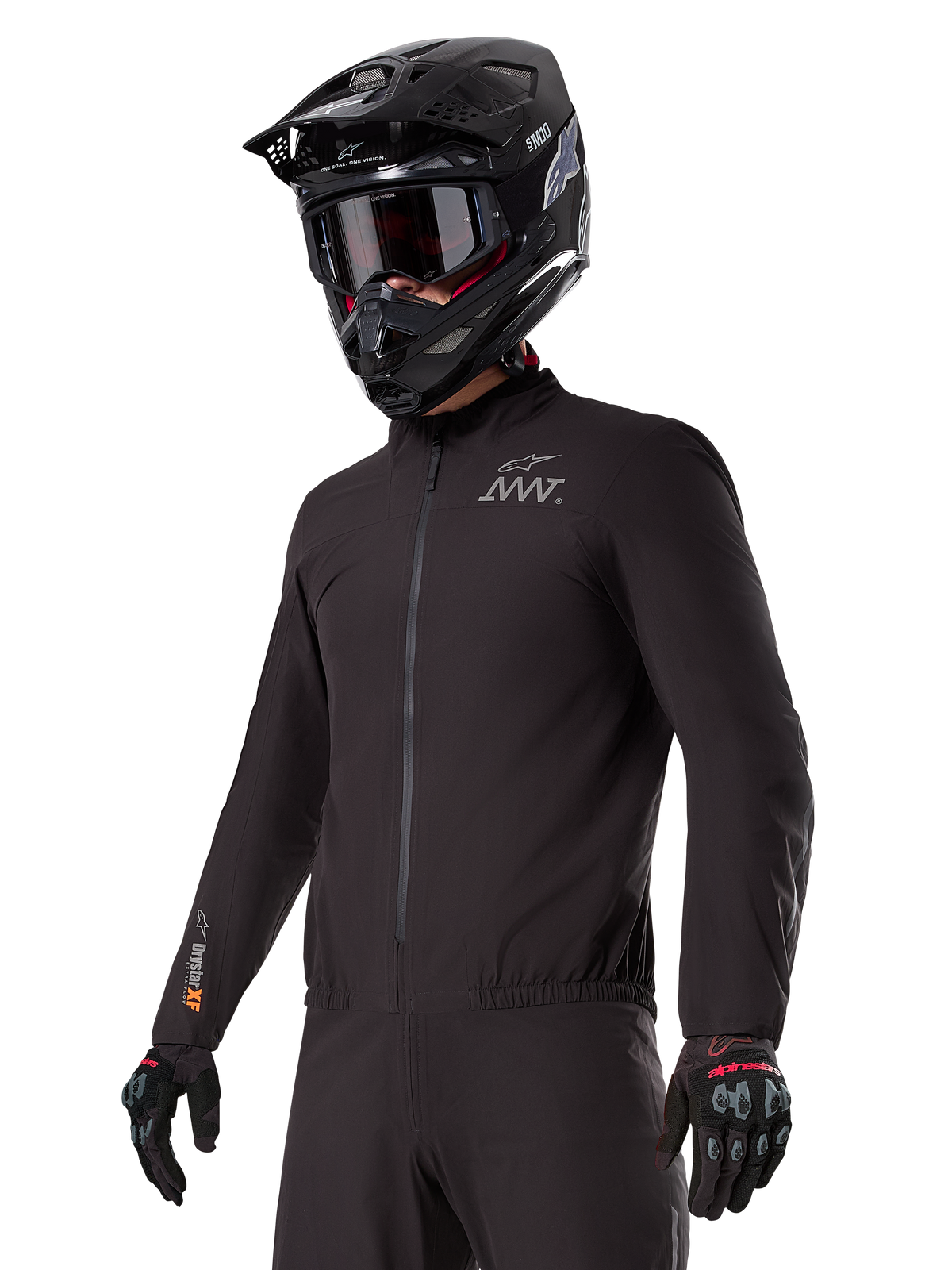Fahrer trägt den Alpinestars AMT-8 Stretch Drystar® XF Liner, schwarze wind- und wasserdichte Stretchjacke, mit AMT-Logo auf der Brust und Drystar-XF-Branding auf dem Ärmel, kombiniert mit einem schwarzen Adventure-Helm und Schutzhandschuhen.