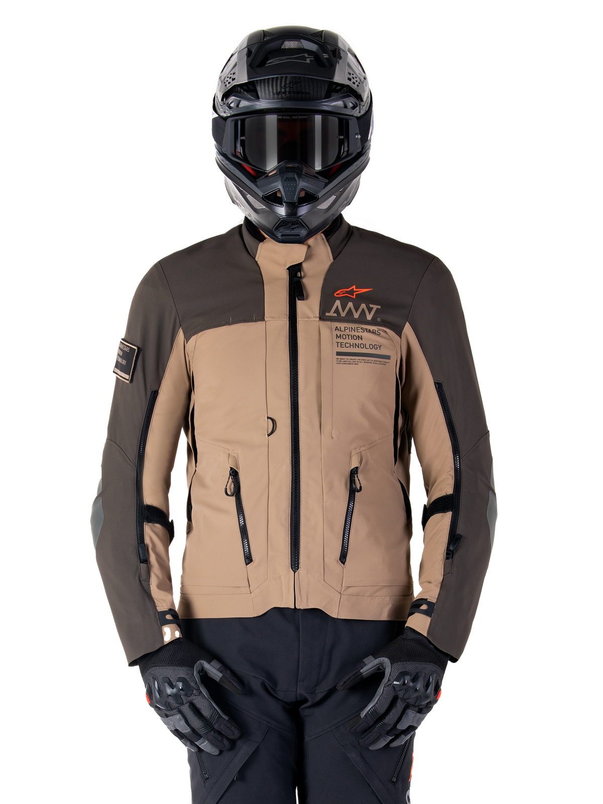 Alpinestars AMT-8 Stretch Drystar XF jas, adventure touring motorjas, donkerkhaki en donkerbruin, voorzien van oranje Astars-logo en zwarte ritsen, gedragen met zwarte adventure-helm en handschoenen, volledige motoruitrusting