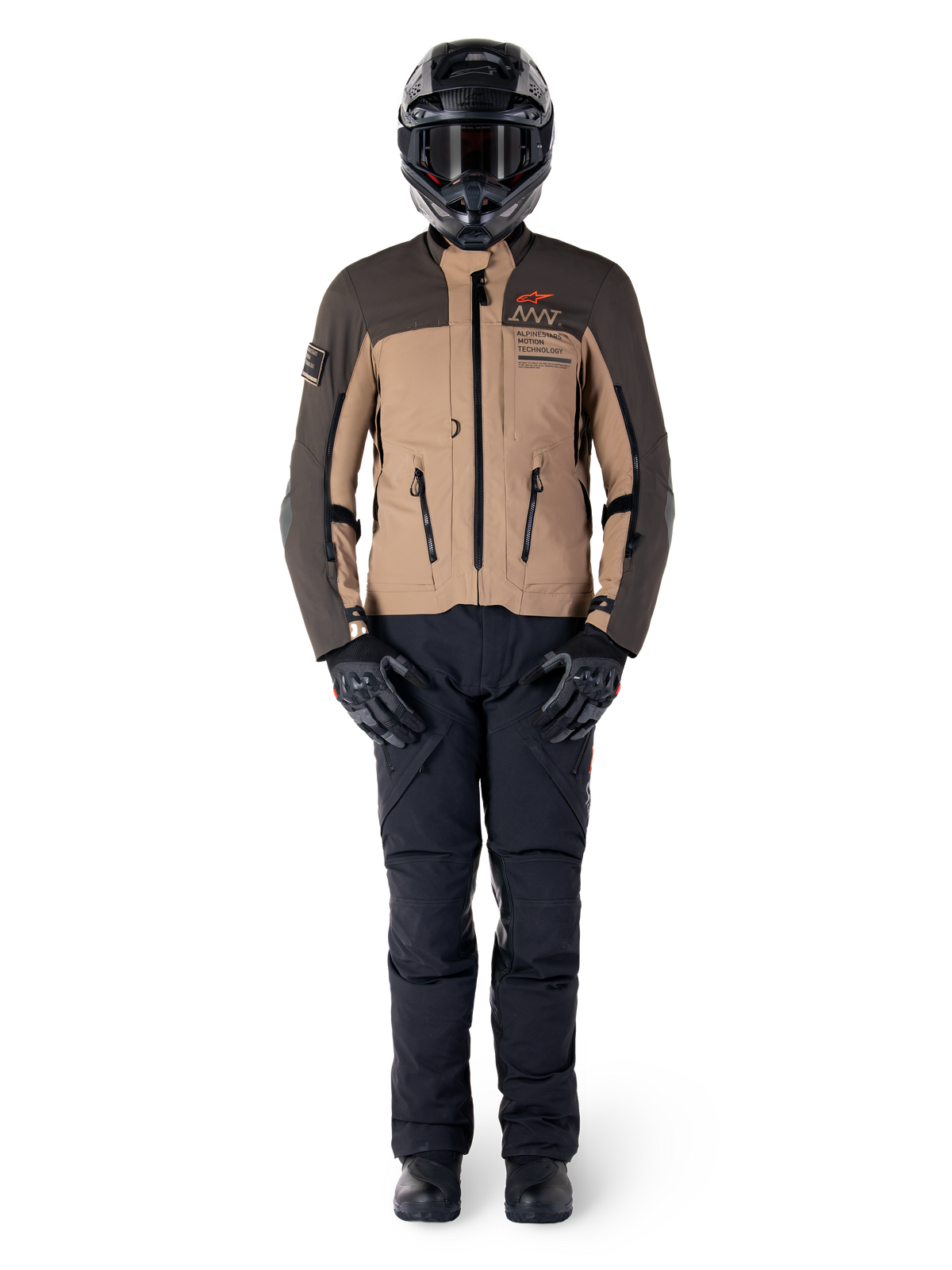 Alpinestars AMT-8 Stretch Drystar® XF Jas, adventure motorjas, donkerbruin en donkerkhaki, gedragen met een zwarte helm, motorbril, zwarte handschoenen, zwarte broek en zwarte laarzen, voorzien van ventilatieopeningen op de borst en AMT-branding, gecoördineerde uitrusting voor adventure touring