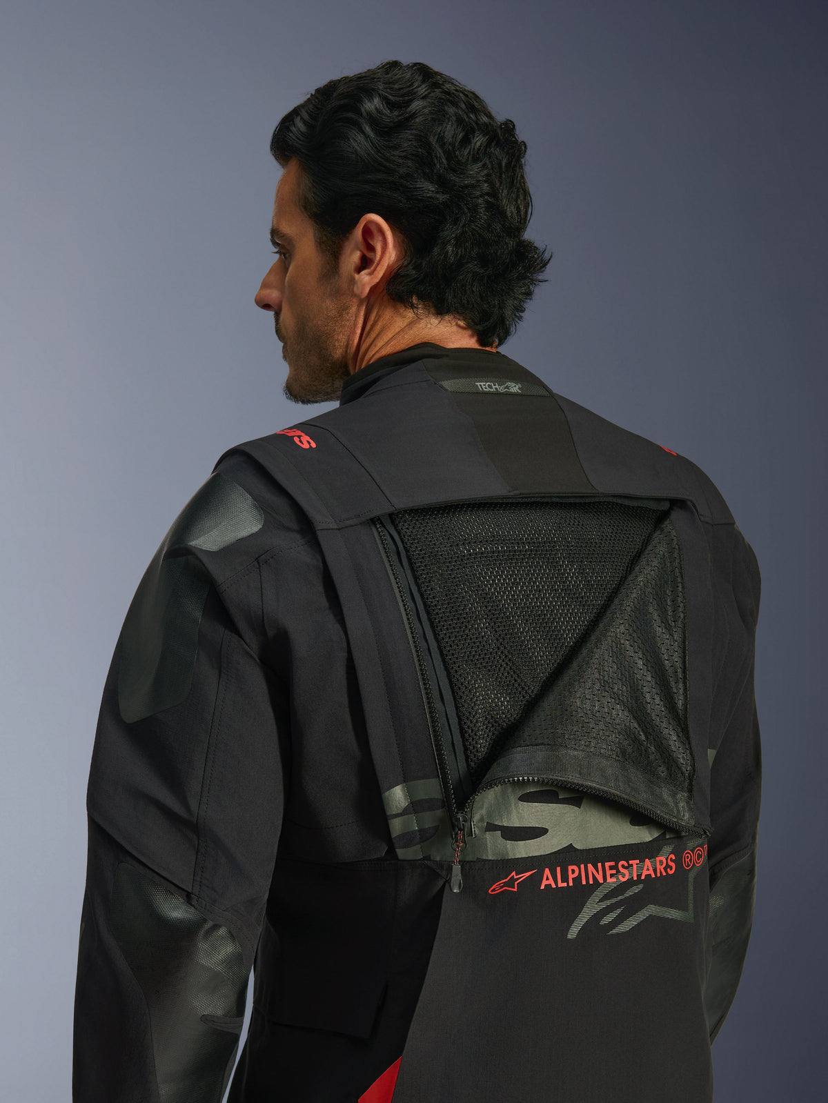 Alpinestars Halo Pro Drystar® XF Laminated Jacket, adventure motorjas, Black Dark Shadow, achteraanzicht met een geopend modulair ventilatiepaneel dat een groot mesh-gedeelte onthult, rode Alpinestars-branding, Tech-Air® Ready-logo op de kraag, duurzame textielconstructie voor rijden op alle terreinen.