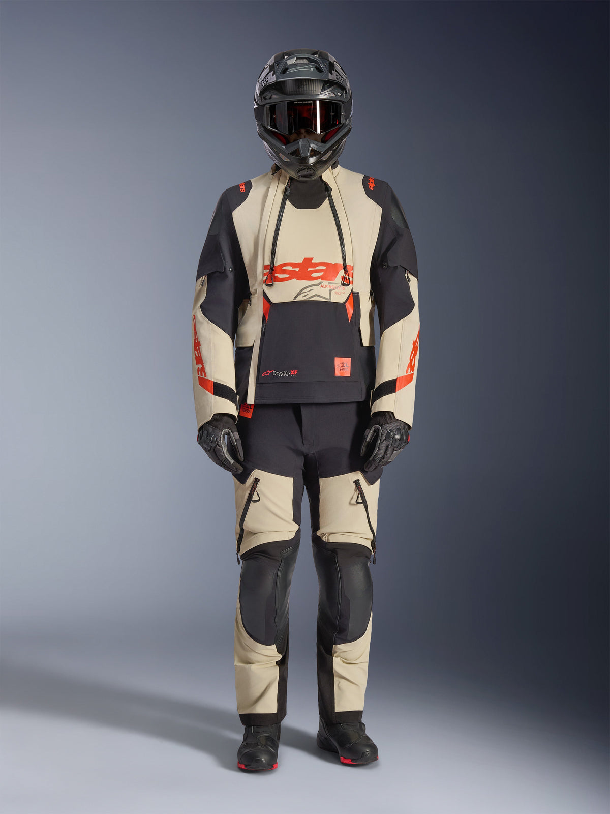 Alpinestars Halo Pro Drystar® XF Laminated Jacket, Adventure Motorcycle Jacket, Mastic Black, beige and black with orange accents, worn with matching pants, helmet, and gloves, technical design featuring waterproof zippers and modular panels for off-road and road riding