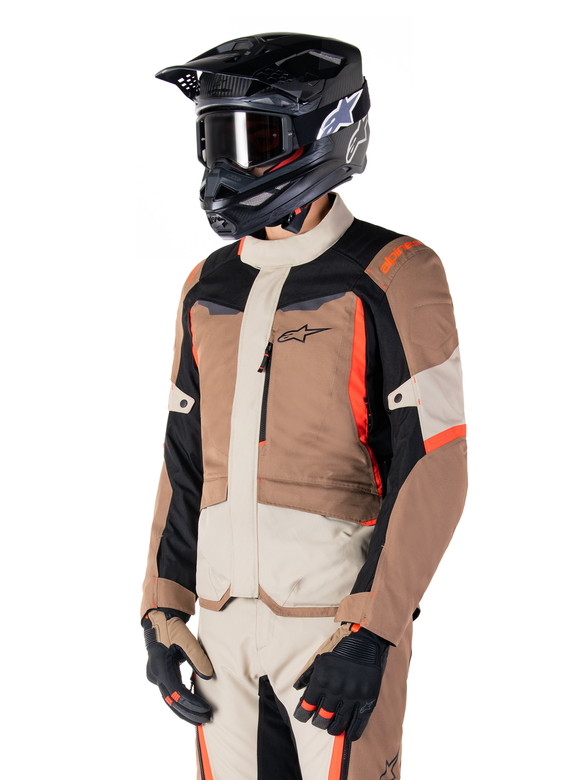 Alpinestars ST-1 Waterproof jas, adventure touring-jas, Dark Khaki Sand Black en Red Fluo, gedragen door een rijder met een zwarte motorcrosshelm en bril, voorzien van een multi-panel ontwerp met cargozakken en Alpinestars-branding op de borst