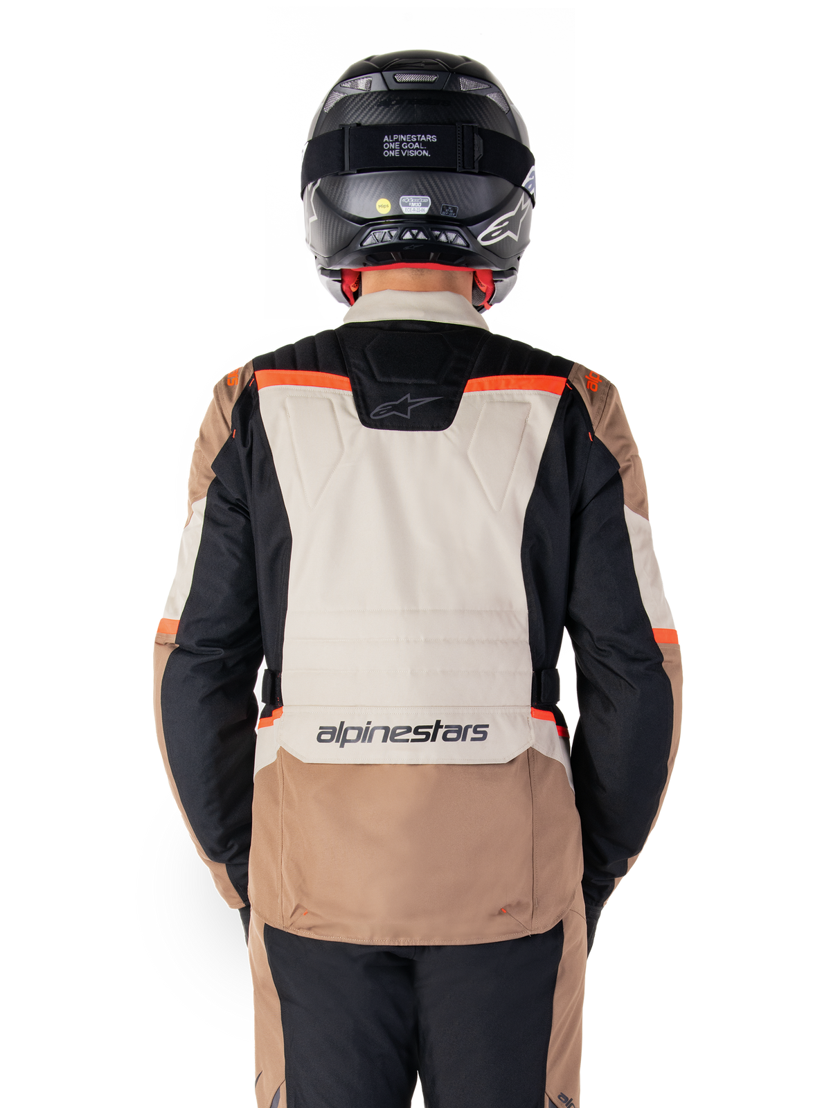Alpinestars ST-1 Waterproof Jas, Dark Khaki Sand Black Red Fluo, achteraanzicht, adventure touring motorjas met een groot zandkleurig rugpaneel, zwarte mouwen en rode fluo accenten, gedragen door een motorrijder met een zwarte helm