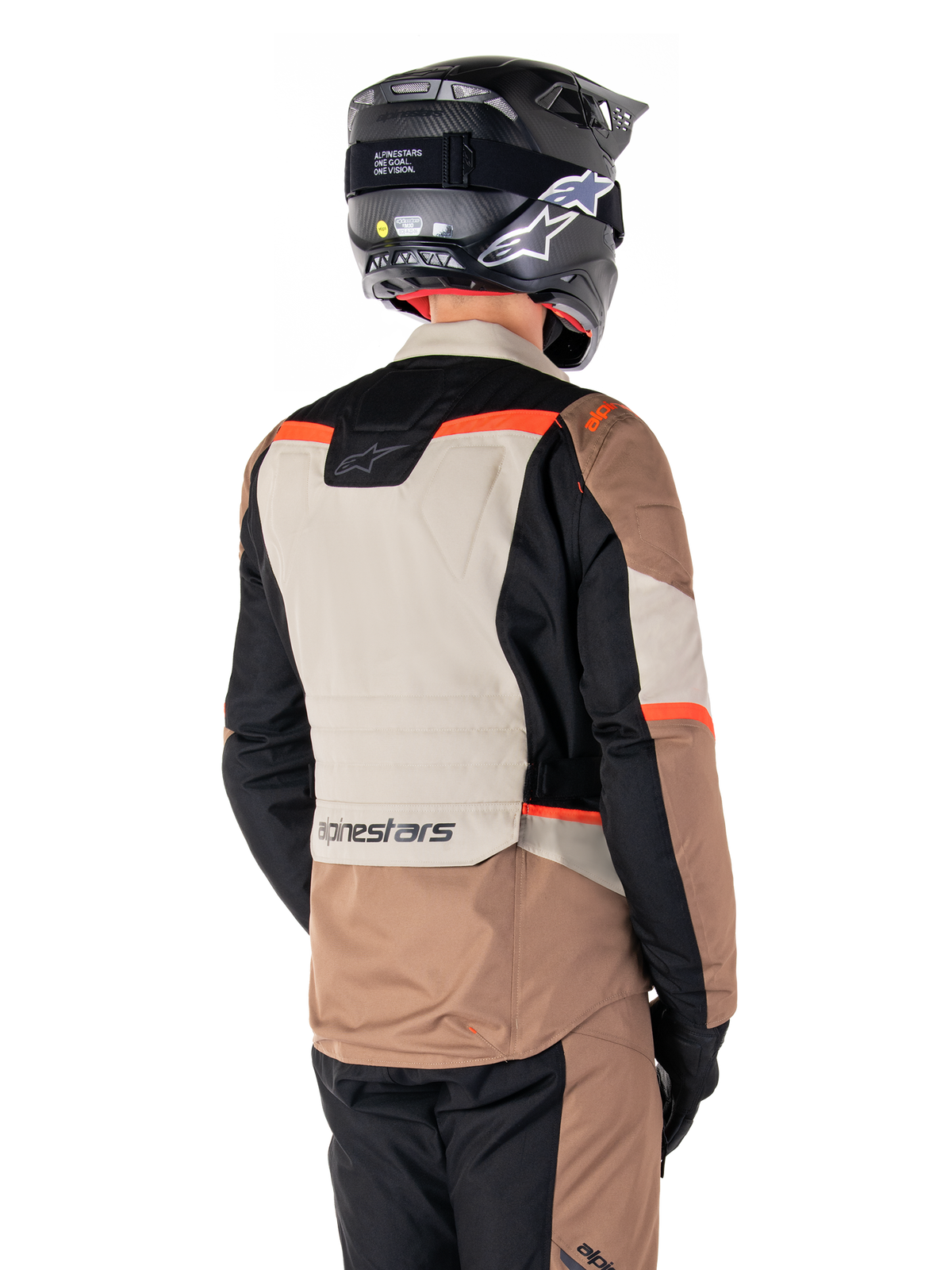 Alpinestars ST-1 Waterproof Jas, Adventure Touring Jas, Dark Khaki Sand Black Red Fluo, achteraanzicht met kleurvlakken van textiel, fluorescerend rode accenten en Alpinestars-logo op de onderrug, gedragen door een rijder met een zwarte helm.