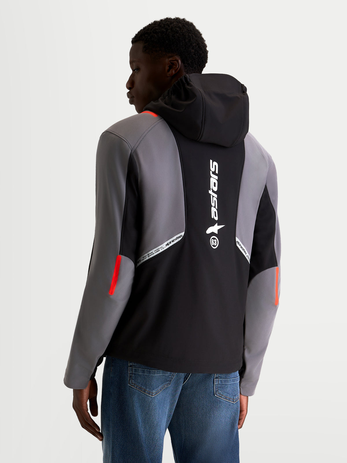 Alpinestars C 5 Drystar jas, urban motorjas voor heren in zwart en donkergrijs, achteraanzicht op model met geïntegreerde capuchon en groot Alpinestars-logo op de rug