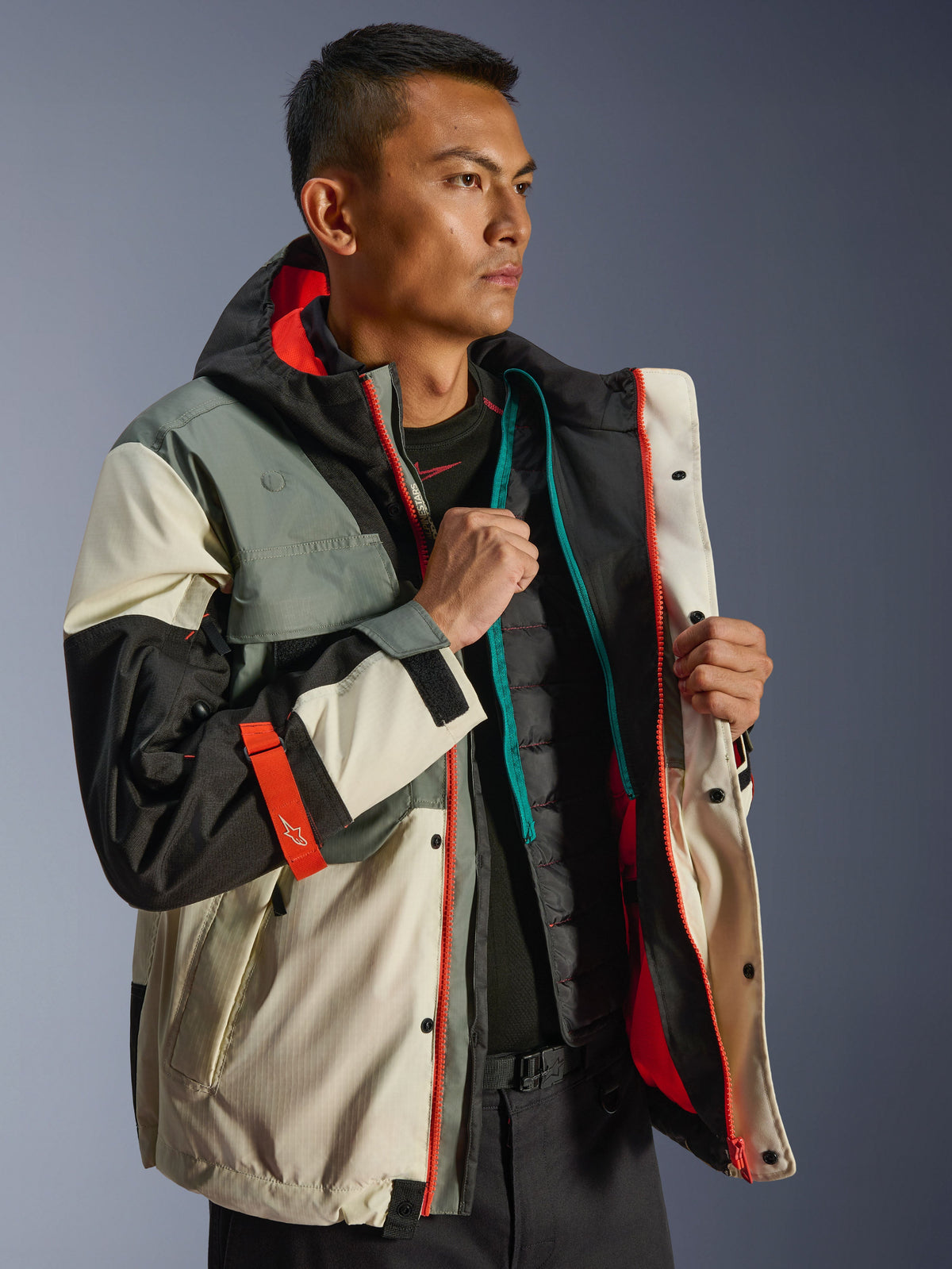 Veste imperméable Alpinestars Mospher, parka de moto urbaine, Fur Gray Black Ice, avec empiècements crème et gris et accents orange vif, présentée ouverte avec un gilet thermique matelassé, design d'inspiration tactique pour toutes conditions météorologiques