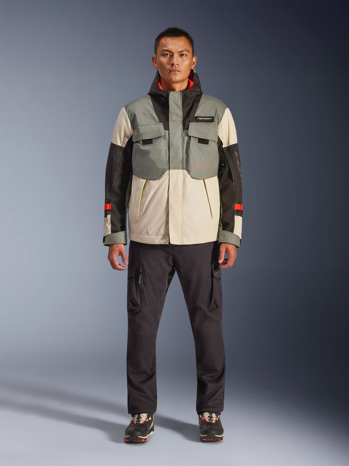 Veste imperméable Alpinestars Mospher WP en Fur Gray Black Ice, parka de moto de style tactique portée par un mannequin homme avec un pantalon cargo sombre, design multi-poches avec empiècements gris, crème et noirs, équipement de conduite pour motard urbain