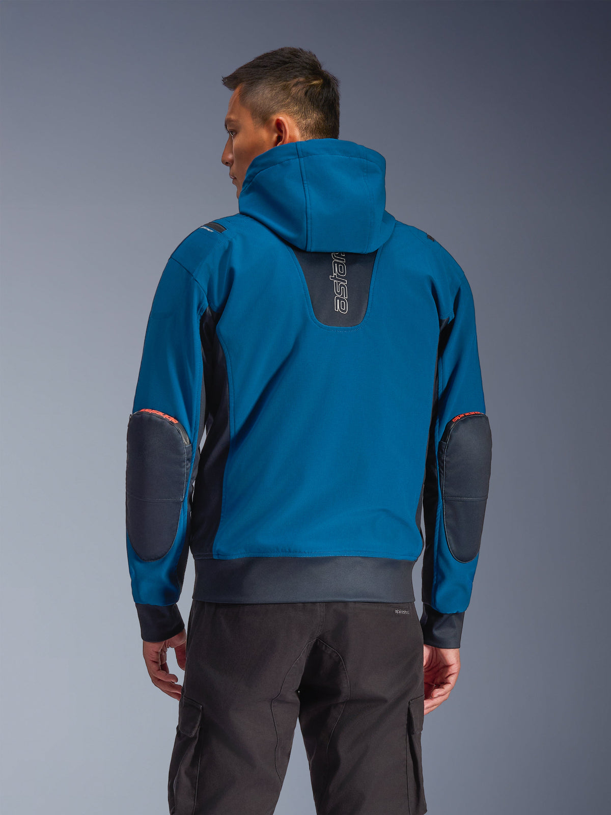 Alpinestars Moblast WP Jacke, Dark Petrol und Dark Navy, urbaner Motorrad-Hoodie in der Rückansicht, mit fester Kapuze, vertikalem „astars“-Logo auf dem oberen Rücken, dunklen verstärkten Ellbogen-Patches, elastischem Bund und Ärmelbündchen, moderne technische Motorradbekleidung