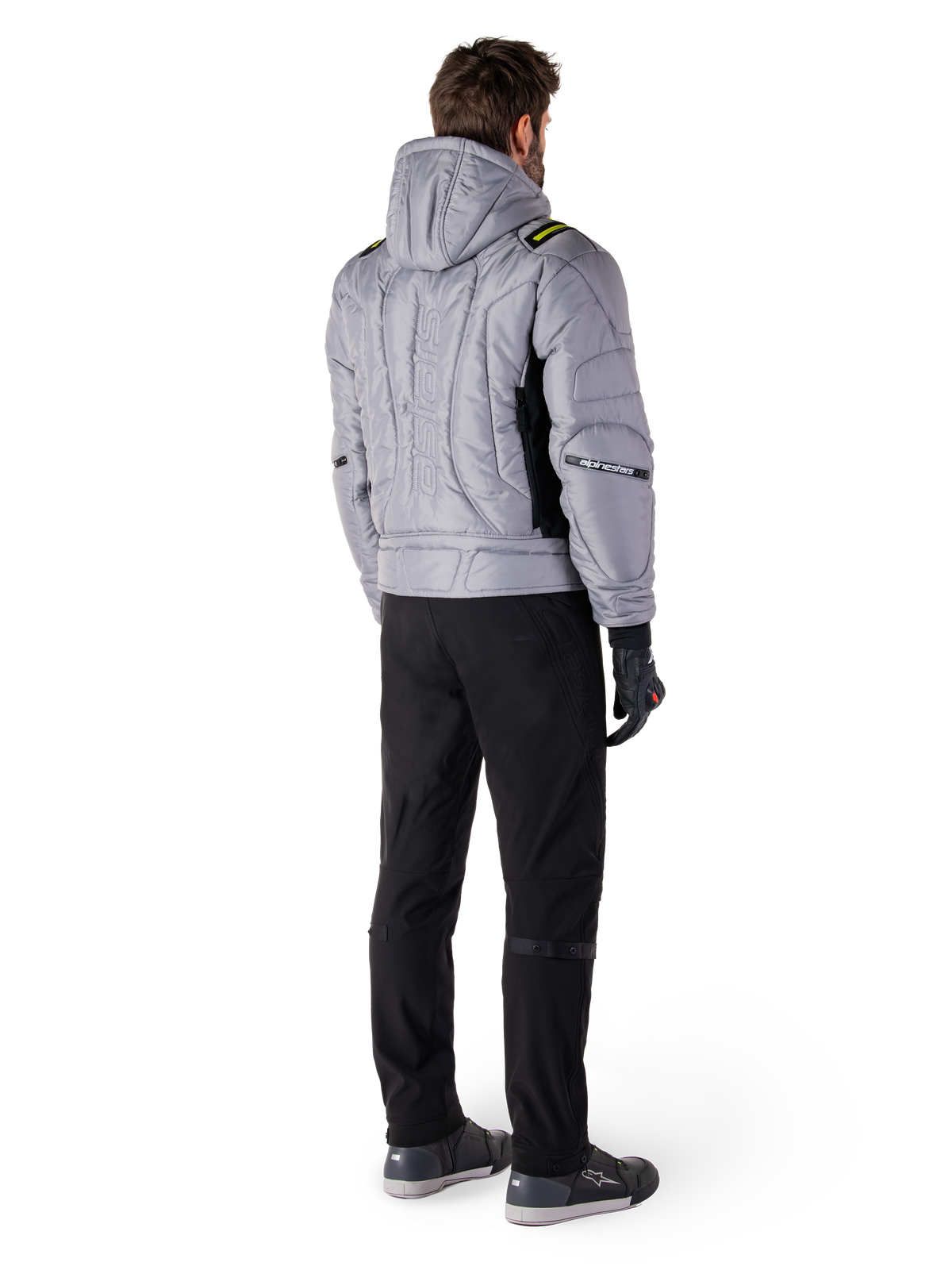 Alpinestars Mohobbs Waterproof Jacket, Lunar Gray Lime Punch, achteraanzicht van gewatteerde motorjas in bomberstijl met capuchon, voorzien van Alpinestars-woordmerk op de rug, gedragen met zwarte motorbroek en handschoenen, urban moto streetwear