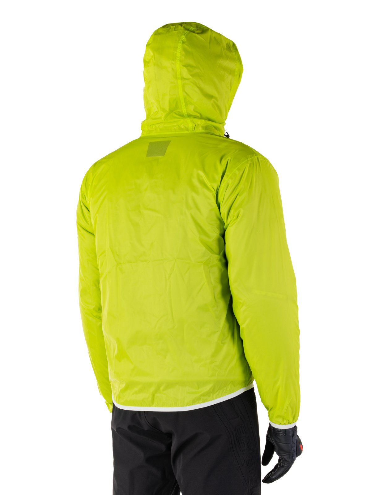 Alpinestars Mohobbs Waterproof Jacket, opvouwbare regenvoering in Lime Punch, achteraanzicht van de neongroene waterdichte laag met capuchon, gedragen met zwarte motorbroek en handschoenen