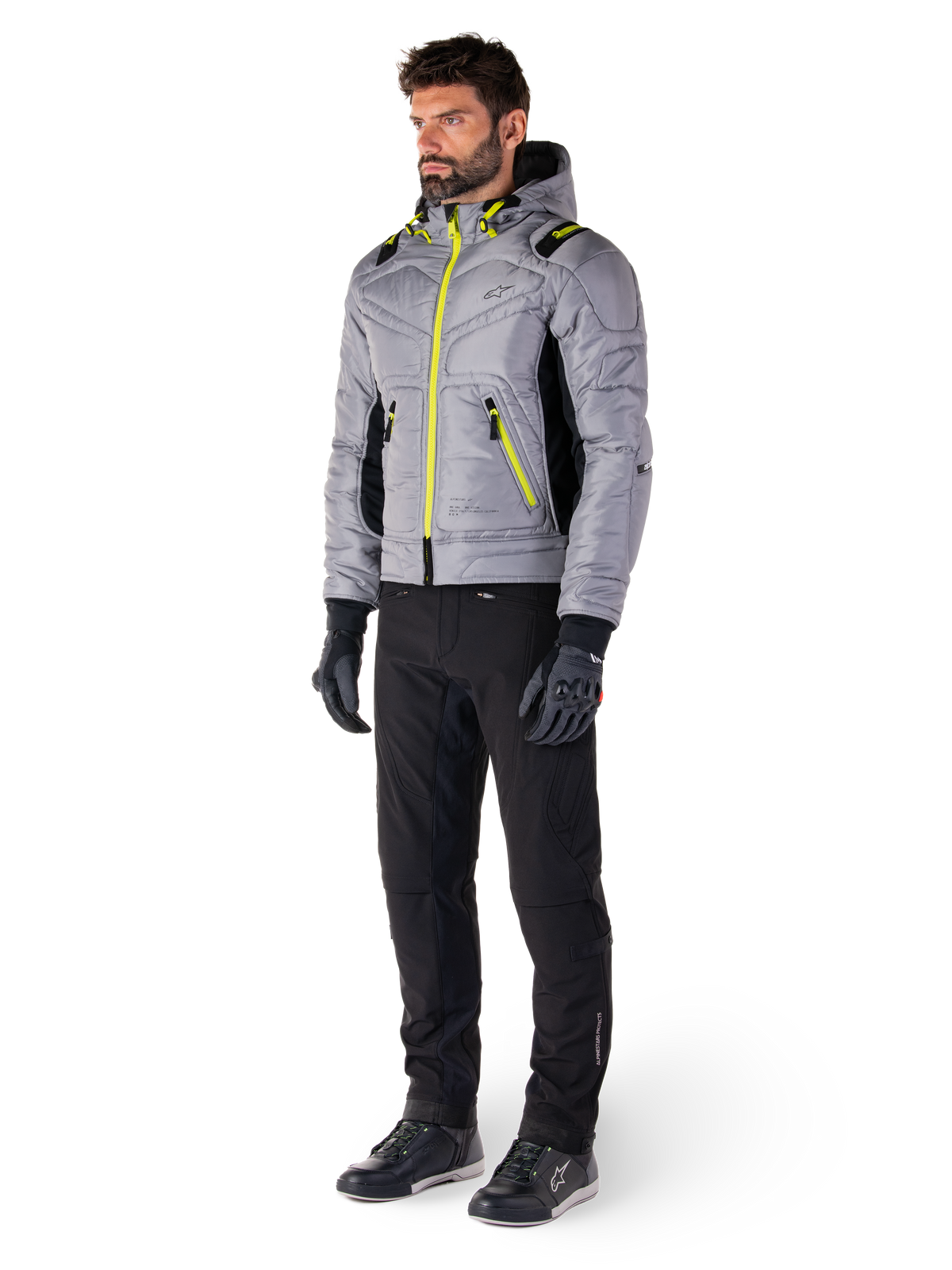Alpinestars Mohobbs Waterproof Jacket in Lunar Gray en Lime Punch, gewatteerd bomber-stijl motorjas met neon accenten, gedragen door model met zwarte motorbroek en handschoenen, op urban streetwear geïnspireerde beschermende kleding