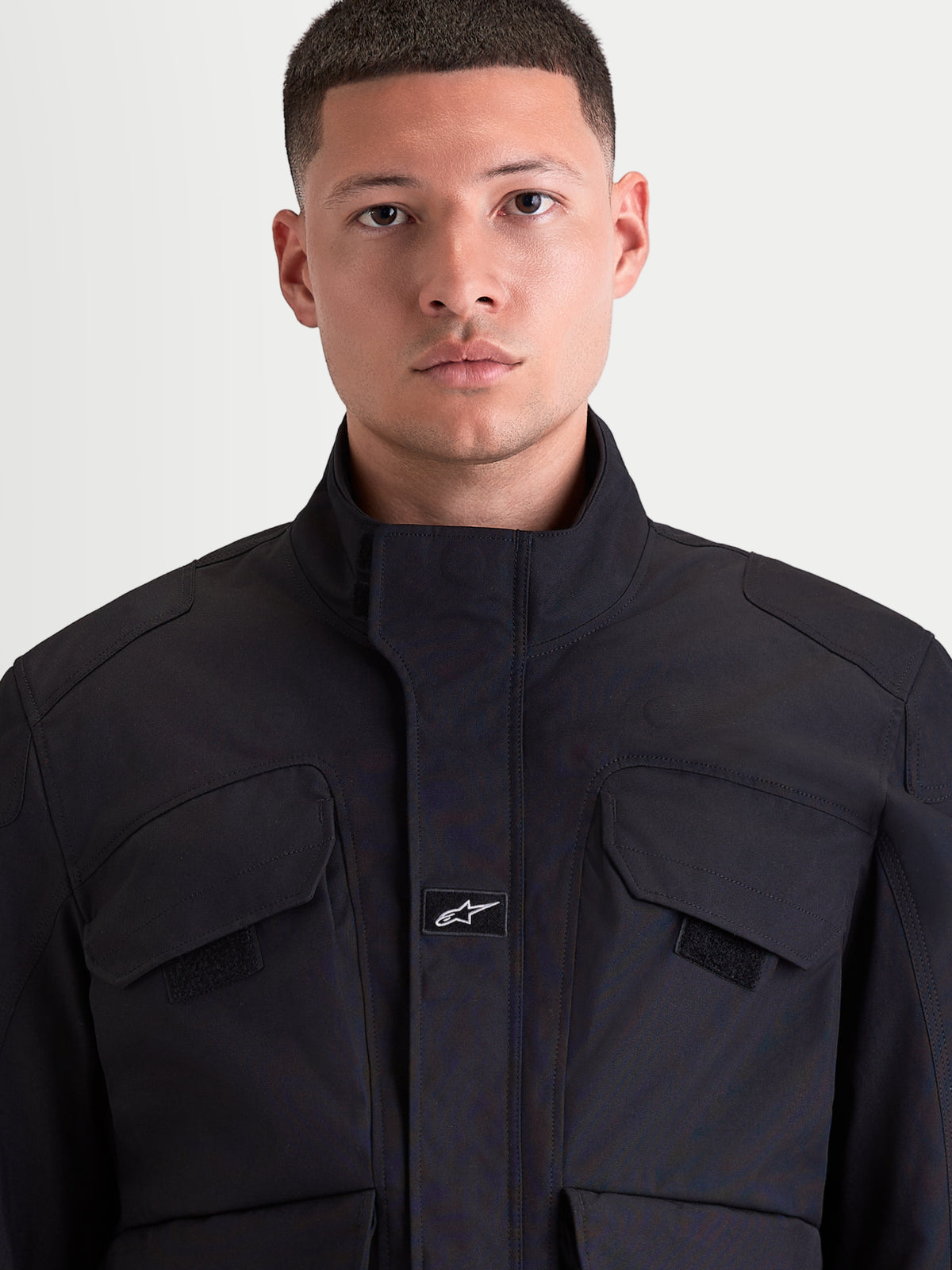 Alpinestars Altan Drystar jas, heren motorjas voor stedelijk gebruik in zwart, detailopname van de voorkant met polystof constructie, geïntegreerde warme kraag en borstzakken gedragen door een model