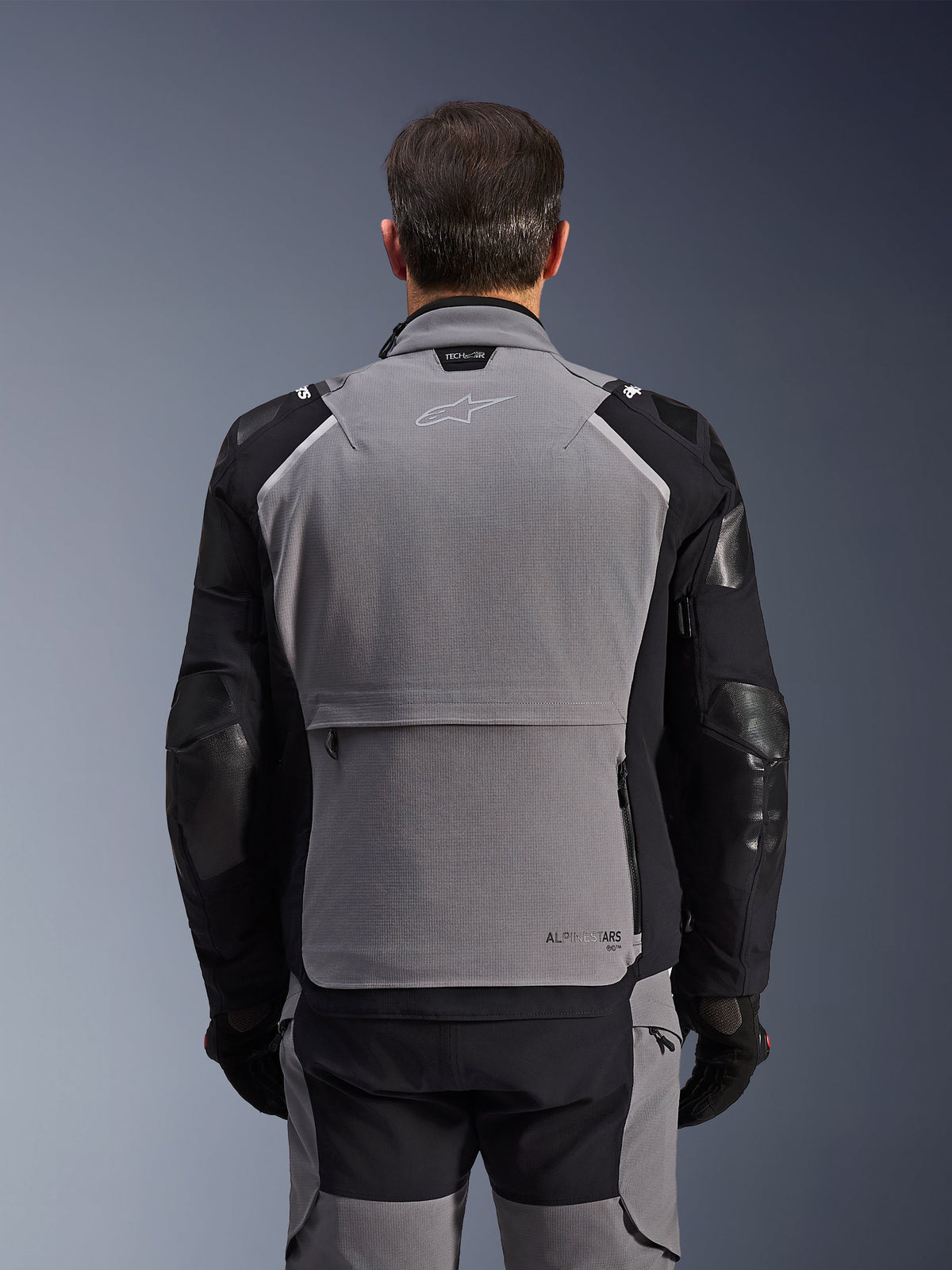 Veste Alpinestars Andes Pro Drystar® XF, vue arrière, gris foncé et noir, veste de touring aventure dotée d'une grande poche de rangement arrière, du marquage Tech-Air® Ready sur le col et d'empiècements renforcés aux coudes.