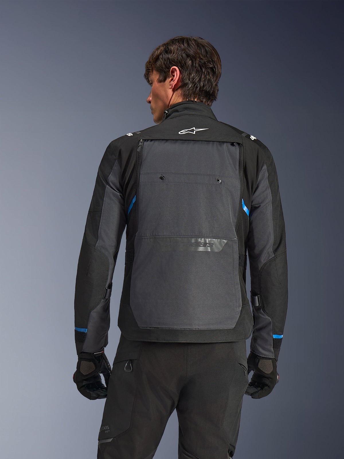 Alpinestars Cusco Drystar® Jacket, Motorcycle Jacket, Black and Deep Gray, back view on a model showing large gray rear panel, white Alpinestars logo, and blue accents on sleeves.