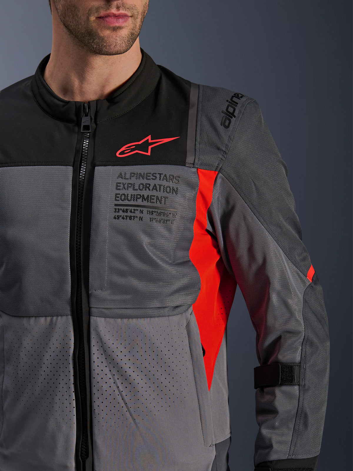 Alpinestars ST-2 Air jas, textiele heren motorjas voor touring, grijs en rood, voorzien van ademend mesh en laserperforaties met Exploration Equipment-branding.
