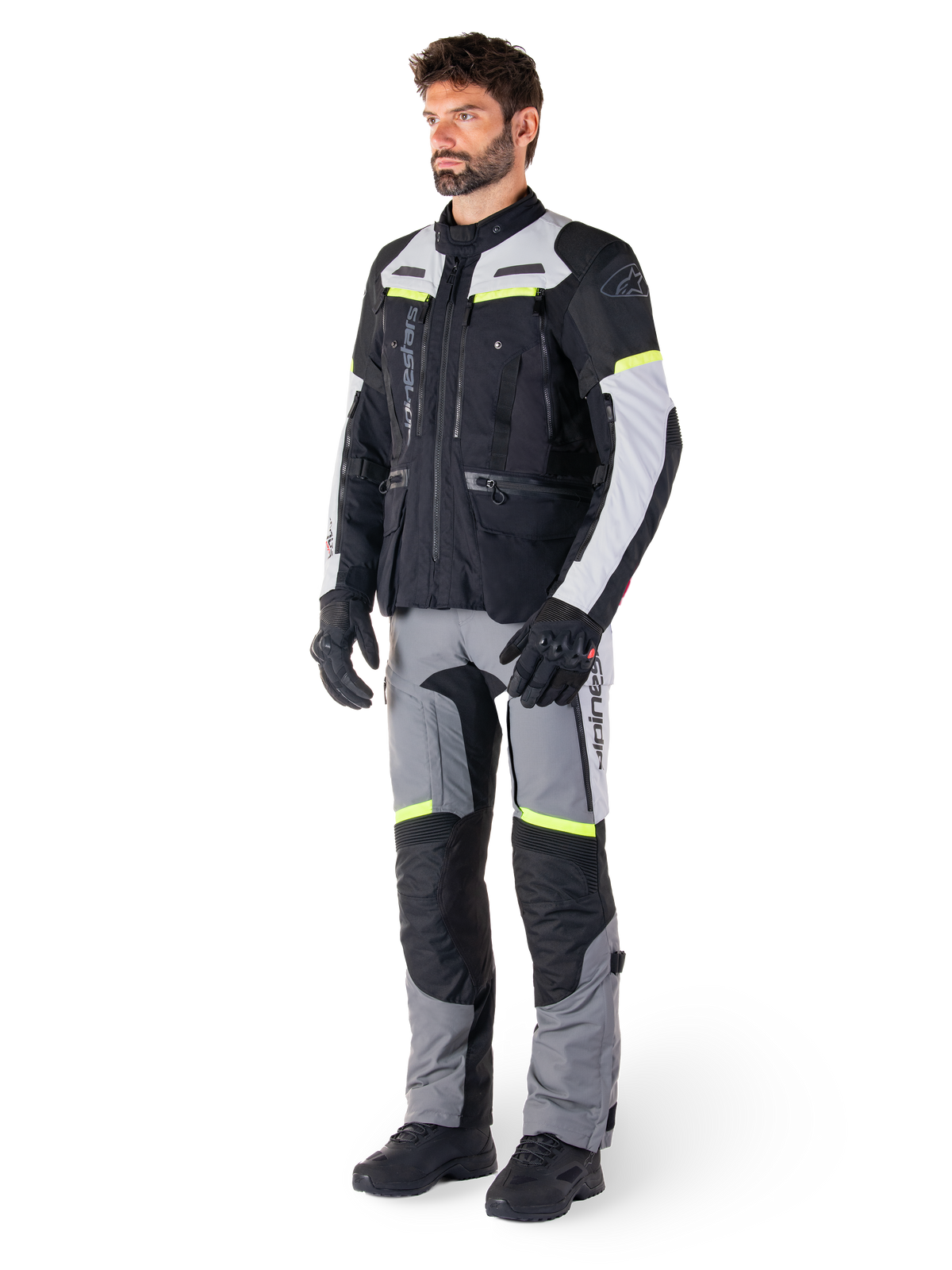 Alpinestars Bogotá Pro Drystar® jas, heren-adventure touring motorjas in zwart en grijs met fluorgele accenten, gedragen door model met bijpassende broek.