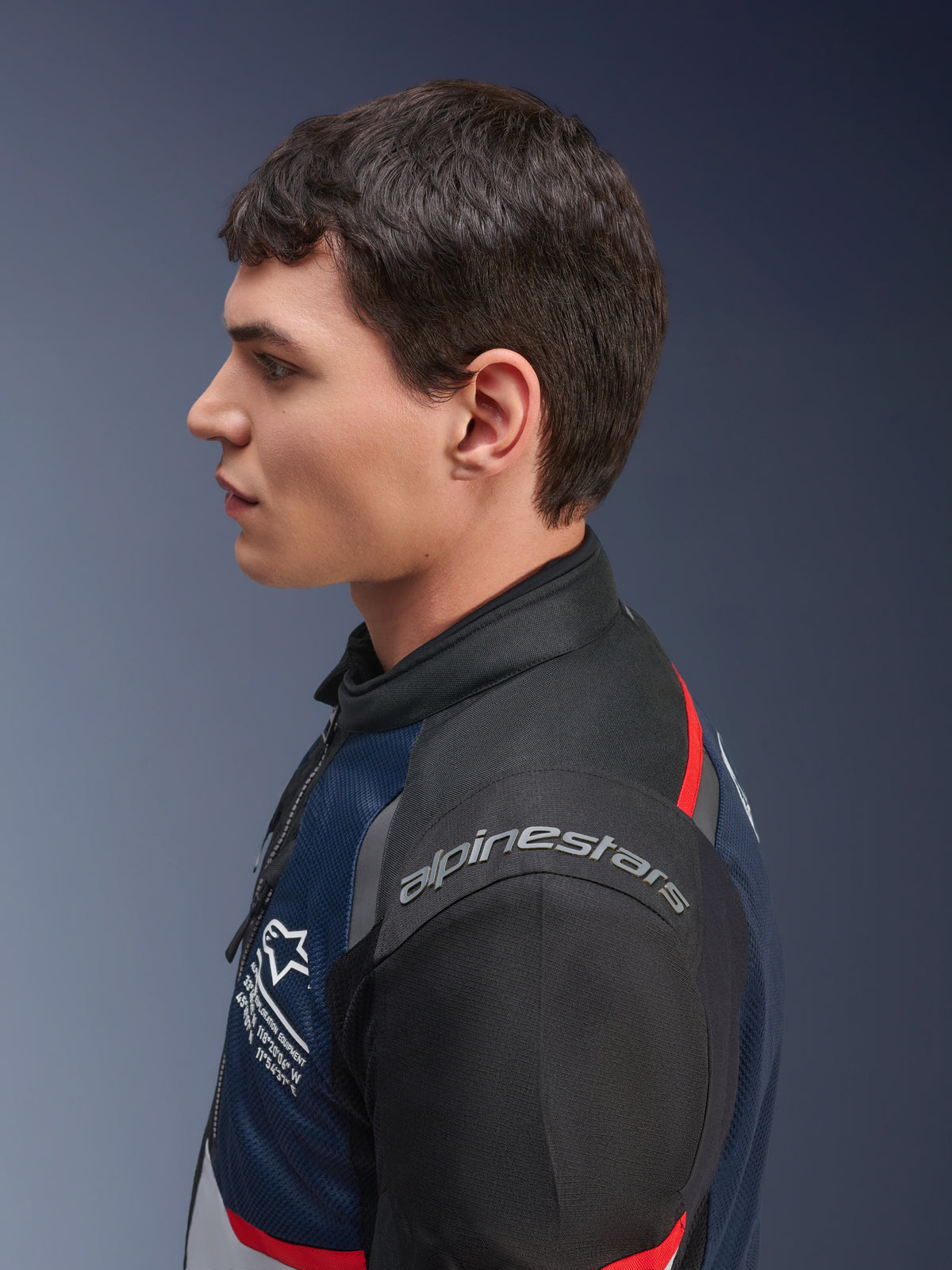 Alpinestars Andes Air Drystar® jas, Deep Blue Black Ice Gray kleurstelling, zijprofiel van een mannelijk model dat de mesh textiel jas draagt, voorzien van Alpinestars-branding op de schouder en rode accenten, touringuitrusting voor twee seizoenen