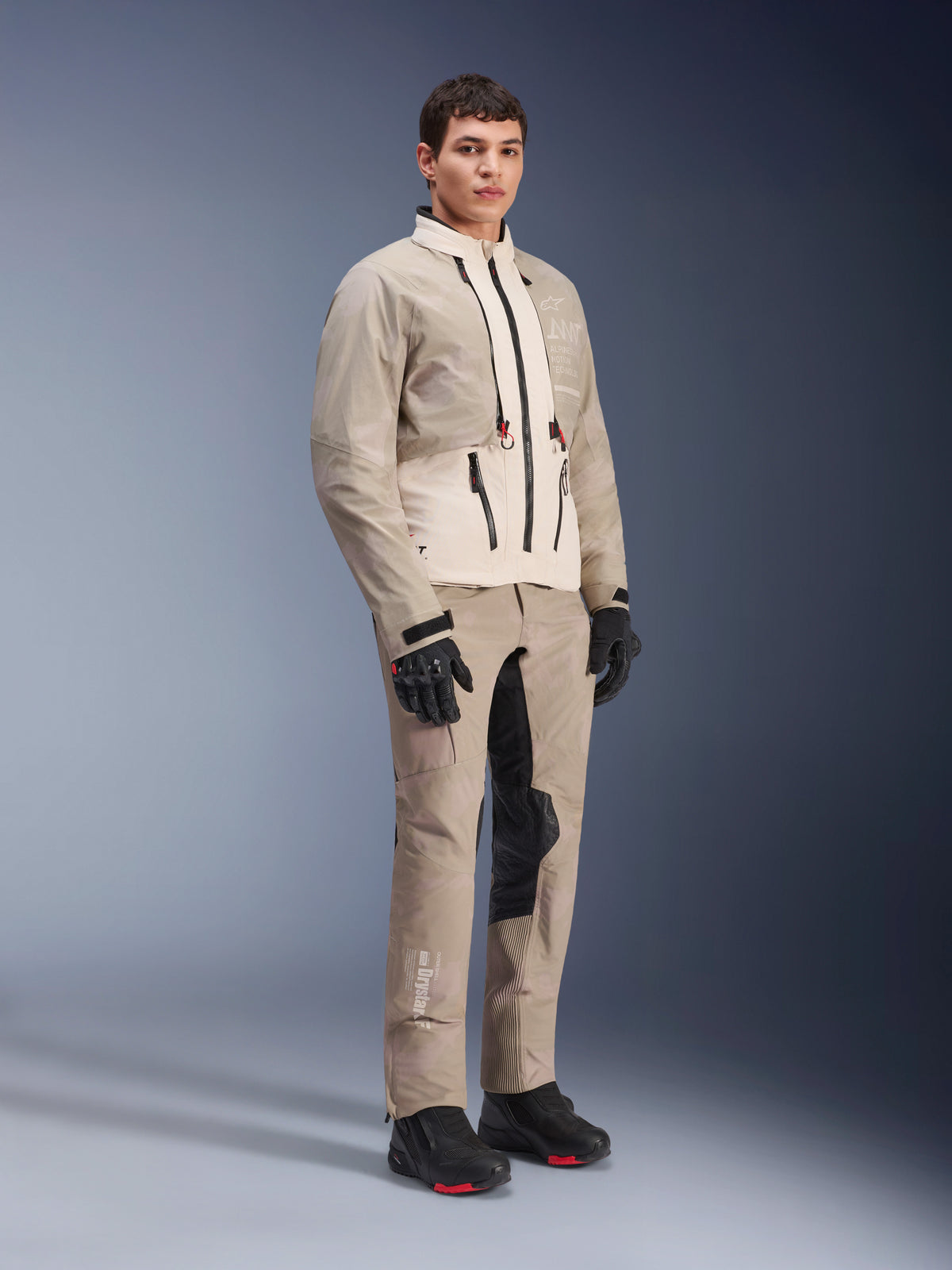 Alpinestars AMT-10LAB Drystar® XF Jacke, Adventure-Motorradjacke, White Sand Aluminum Camo, getragen mit passender Adventure-Hose, schwarzen Motorradhandschuhen und Stiefeln, Ganzkörper-Studioaufnahme, Mehrjahreszeiten-Schutzausrüstung