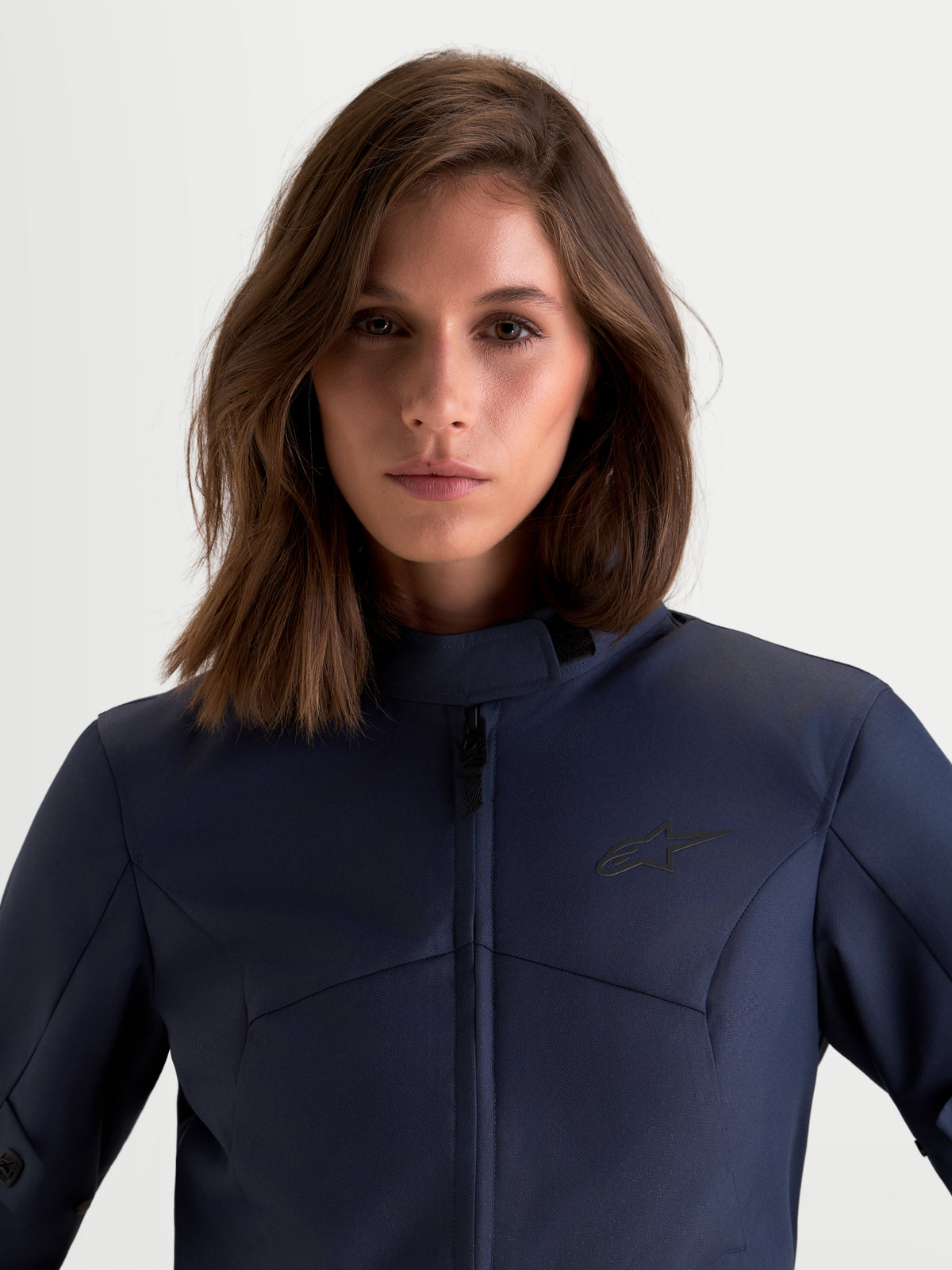 Alpinestars Stella C-1 Waterproof jas, dames motorjas voor urban rijden in mood indigo blauw, close-up van de voorkant met textielconstructie en hoge kraag gedragen door een model