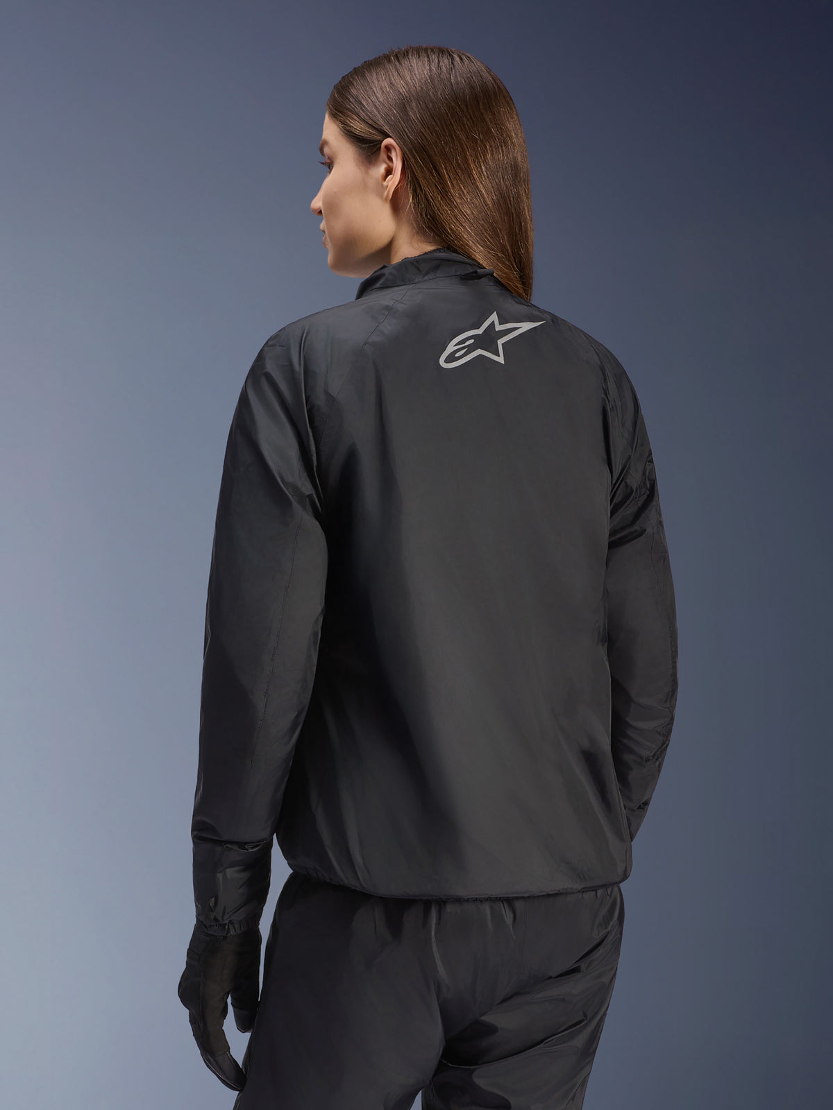 Veste Alpinestars Stella Andes Air Drystar®, veste de moto pour femme, noire, vue arrière montrant le logo étoile argenté, associée à un pantalon et des gants noirs, équipement de touring imperméable léger