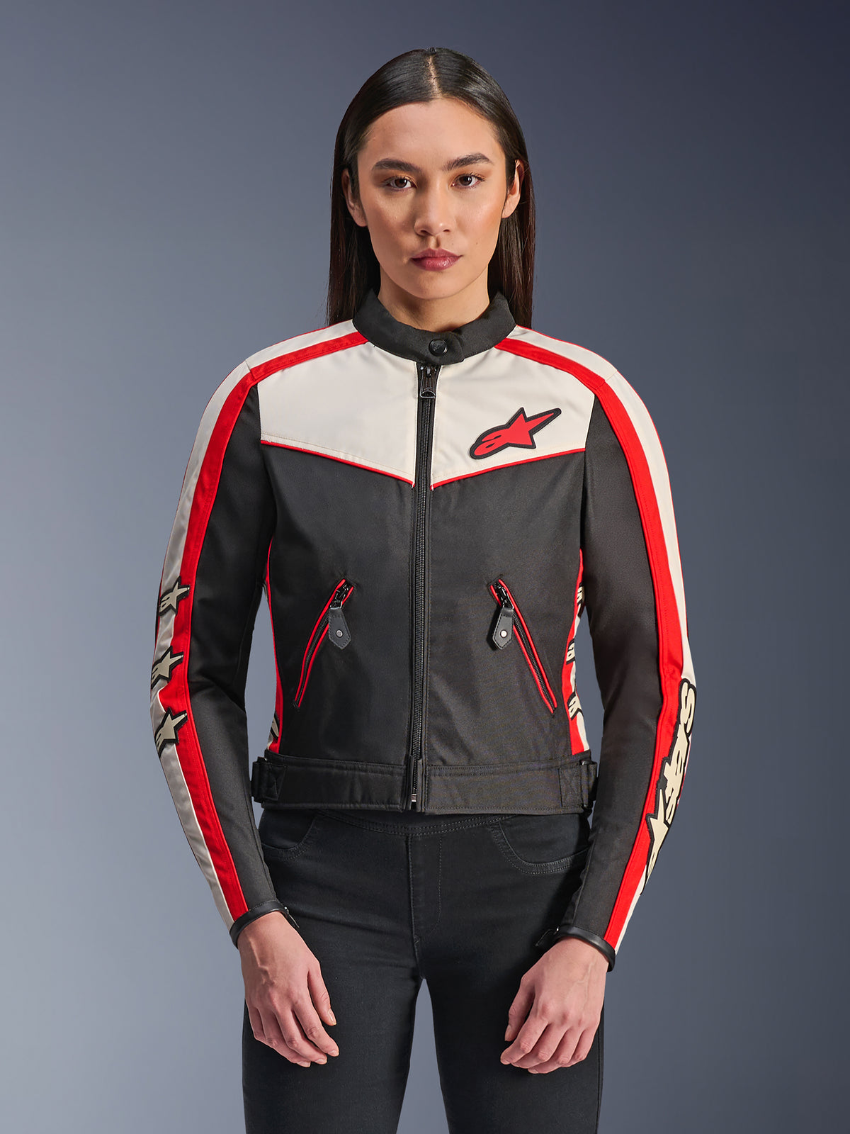 Veste Alpinestars Stella T-Dyno WR, veste de moto en textile pour femme, noir, écru et rouge vif, design d'inspiration vintage avec fermeture éclair frontale, bandes rouges sur les manches avec logos étoiles et poches zippées avec liseré rouge.