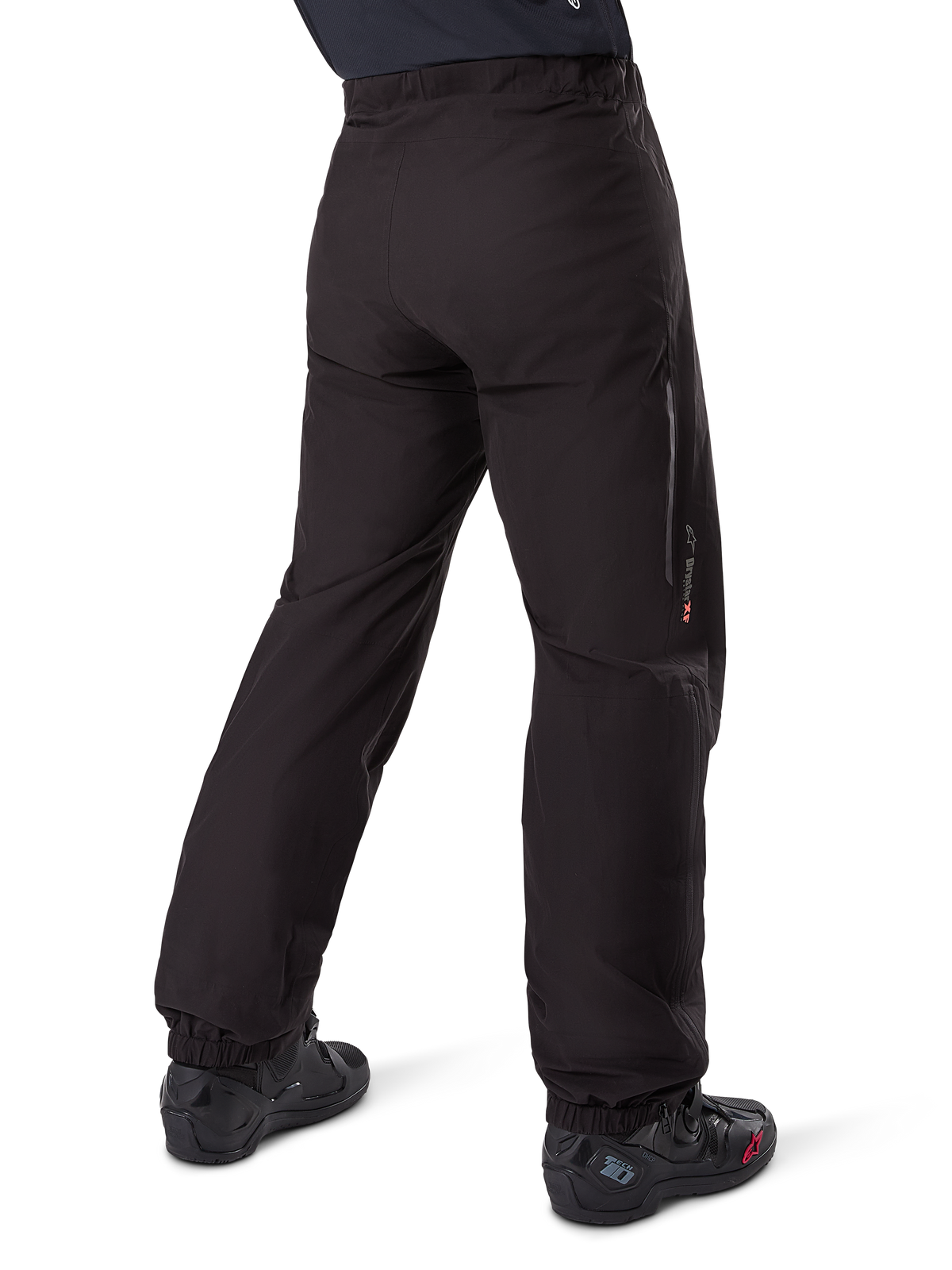 Alpinestars Amt-8 Stretch Drystar® XF Pant Liner, Black, rear view showing the waterproof liner worn over black motorcycle boots, featuring Drystar XF branding on the lower leg, elasticated ankle cuffs, and lightweight stretch material for adventure touring.