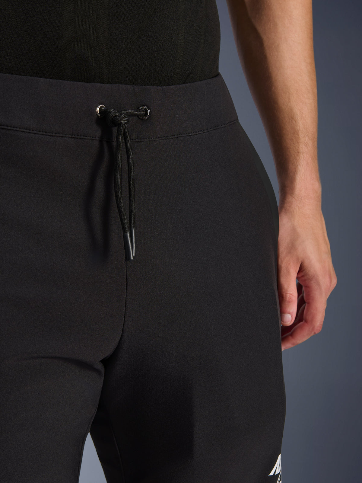 Alpinestars Aeroshell Pants, Black softshell motorcycle pants, close-up view of the elastic waist and drawstring cordon closure, modern minimalist design, durable textile construction for casual touring