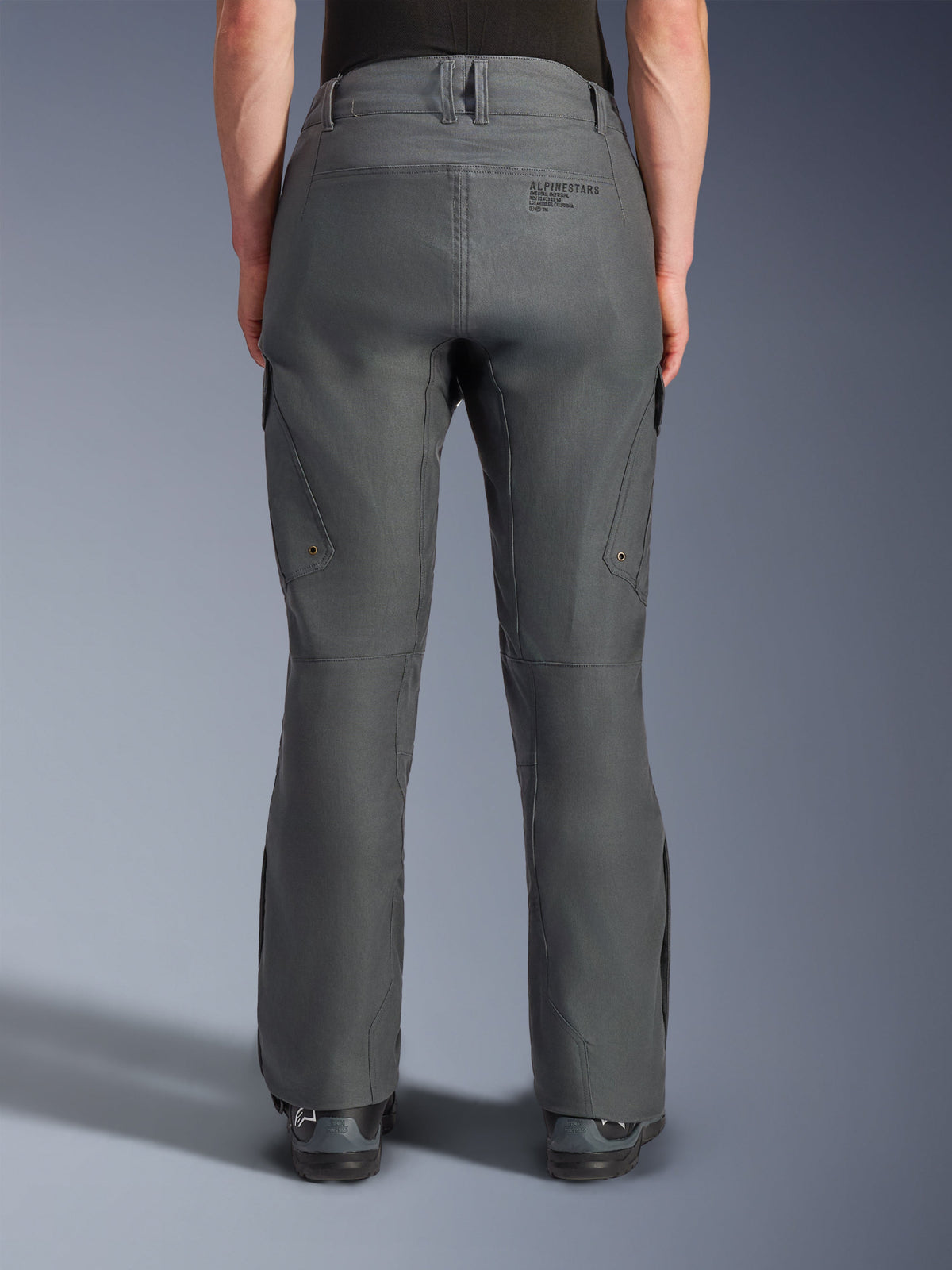 Pantalon Alpinestars Borrego Drystar®, pantalon de moto aventure, gris anthracite, vue arrière montrant la construction textile avec un aspect toile cirée, marquage Alpinestars au dos, poches cargo et passants de ceinture, design robuste et durable pour la conduite aventure