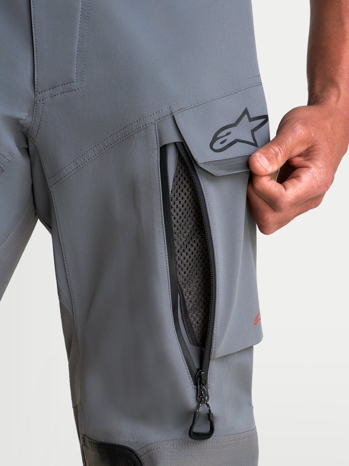 Alpinestars Maxdura Drystar XF Laminated broek, adventure motorbroek voor heren in donkergrijs en zwart, detailopname van de dijventilatie met rits en waterbestendige cargozak met A-star-logo, CE AA-gecertificeerd