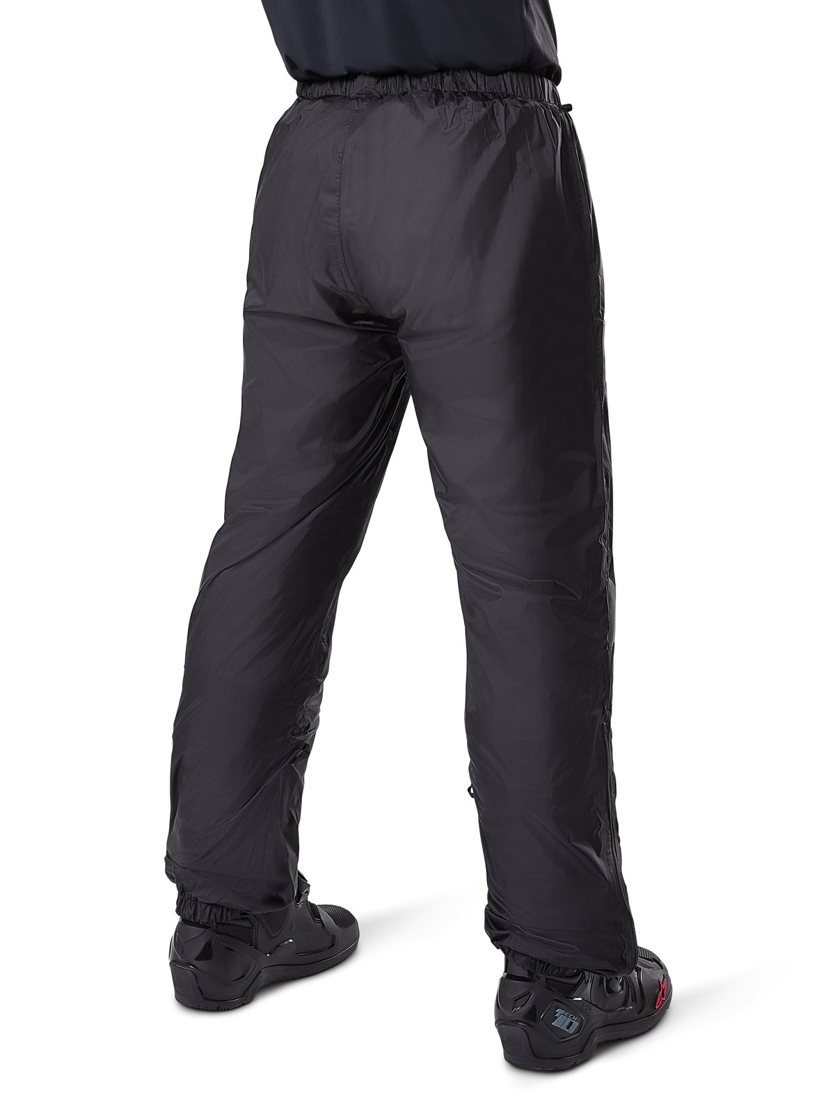 Alpinestars Bogota' Pro Drystar® 3-Jahreszeiten-Hose, schwarze Adventure-Touring-Motorradhose, Rückansicht des wasserdichten Drystar®-Futters als Überhose getragen, kombiniert mit schwarzen Motorradstiefeln, technische Leichtbaukonstruktion für Wetterschutz zu jeder Jahreszeit