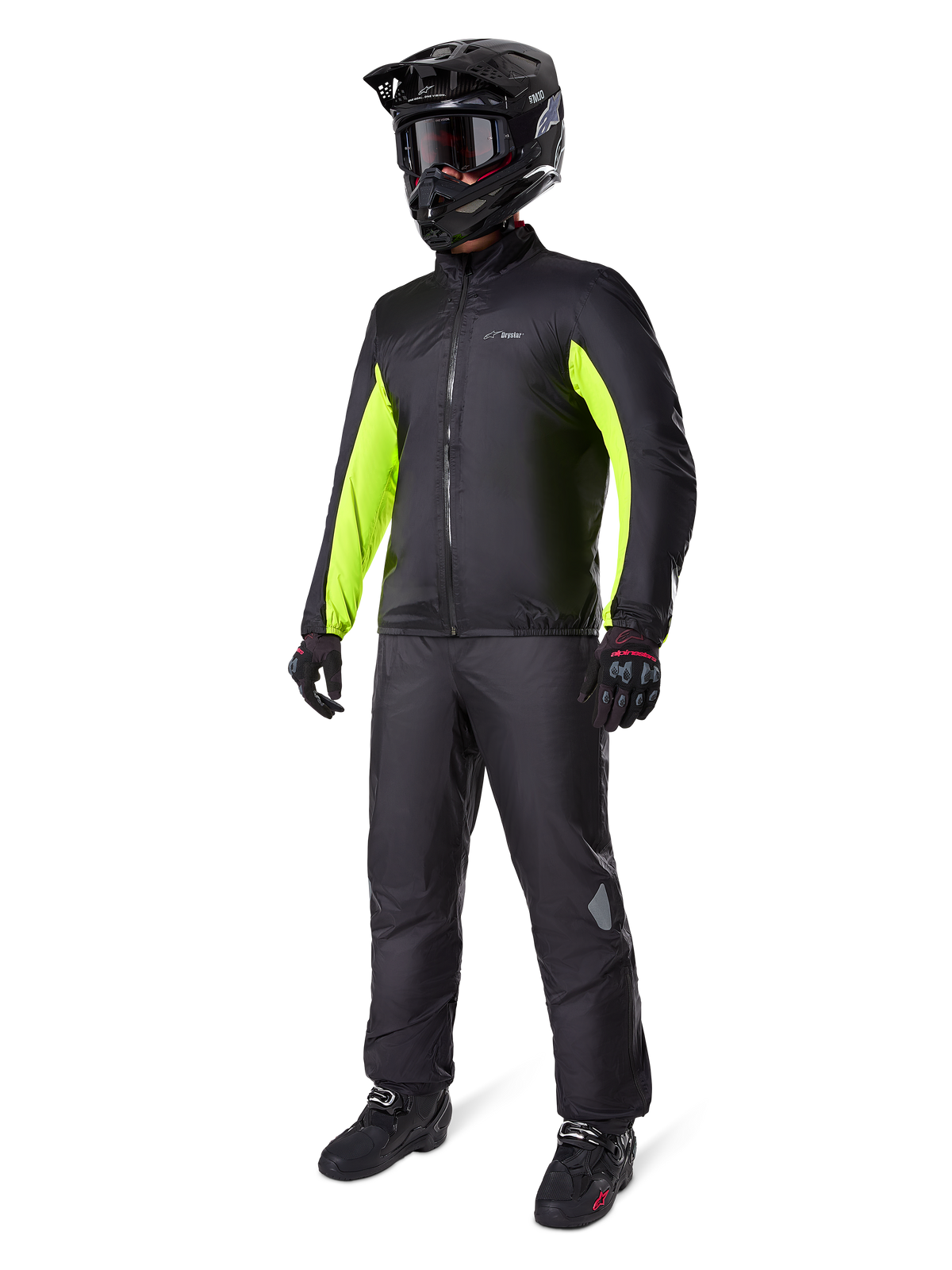 Alpinestars Bogota' Pro Drystar® 3-Jahreszeiten-Hose, Schwarz, Fahrer in kompletter Adventure-Touring-Ausrüstung inklusive schwarzer Jacke mit neongelben Akzenten, schwarzem Helm, Handschuhen und Stiefeln, zeigt die wasserdichte Drystar®-Membran, die über der Hose getragen wird