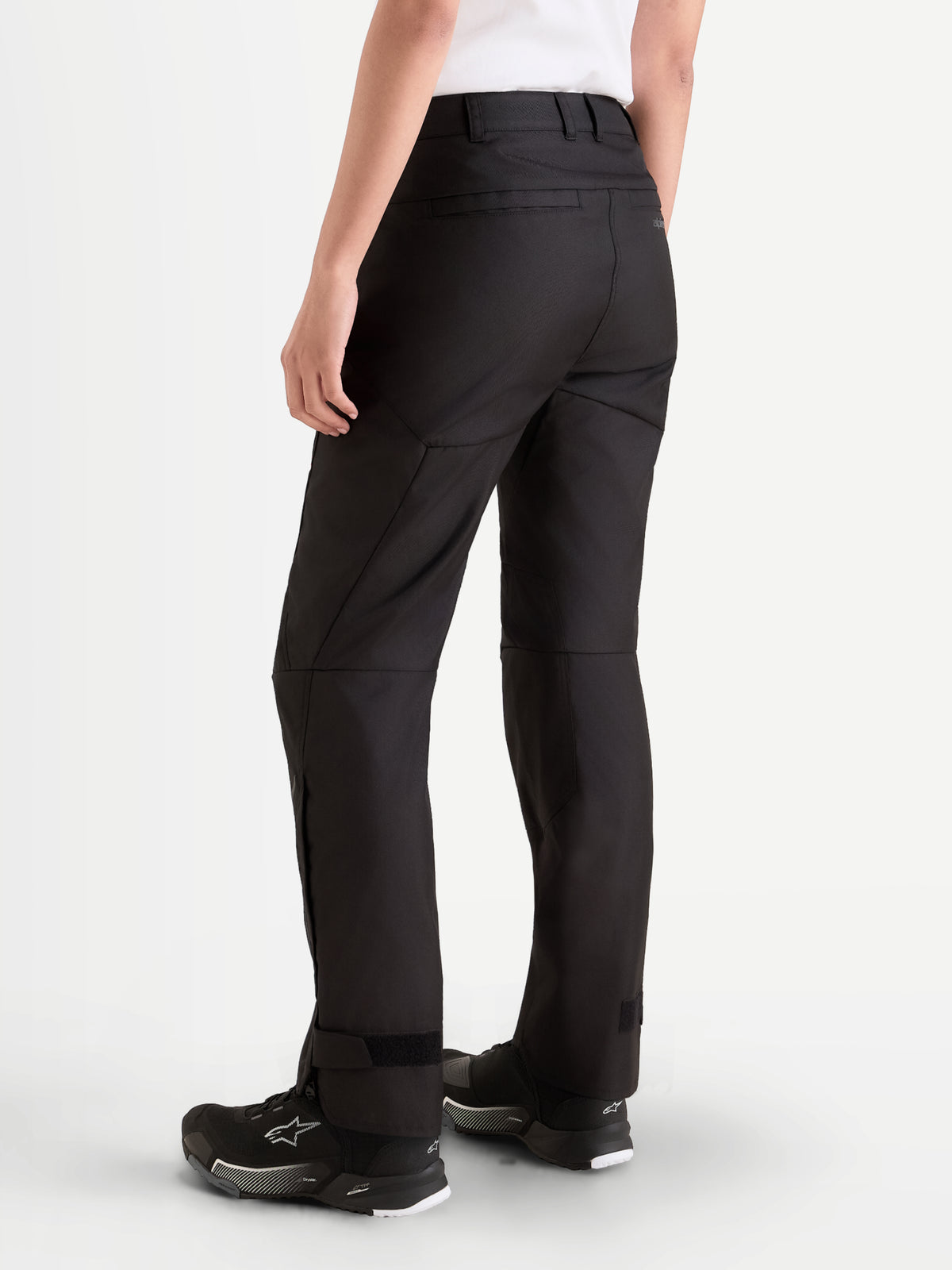 Alpinestars Stella C-1 Waterproof Pants, women's urban contemporary motorcycle riding pants in black, rear three-quarter view showing durable 450D polyfabric construction, belt loop design, and straight-leg fit worn by a model.
