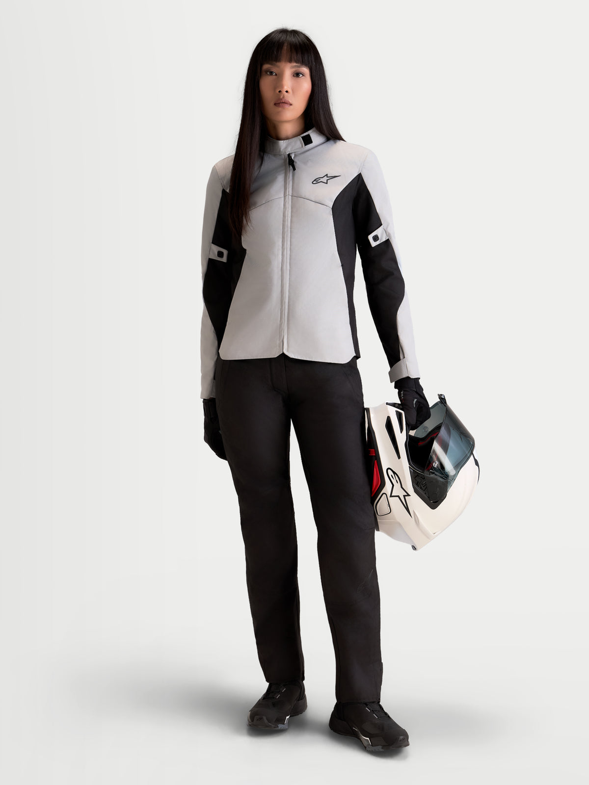 Alpinestars Stella C-1 Waterproof broek, urban motorbroek voor dames in zwart, vooraanzicht op model met bijpassende jas en helm, CE-gecertificeerde bescherming tegen weersinvloeden