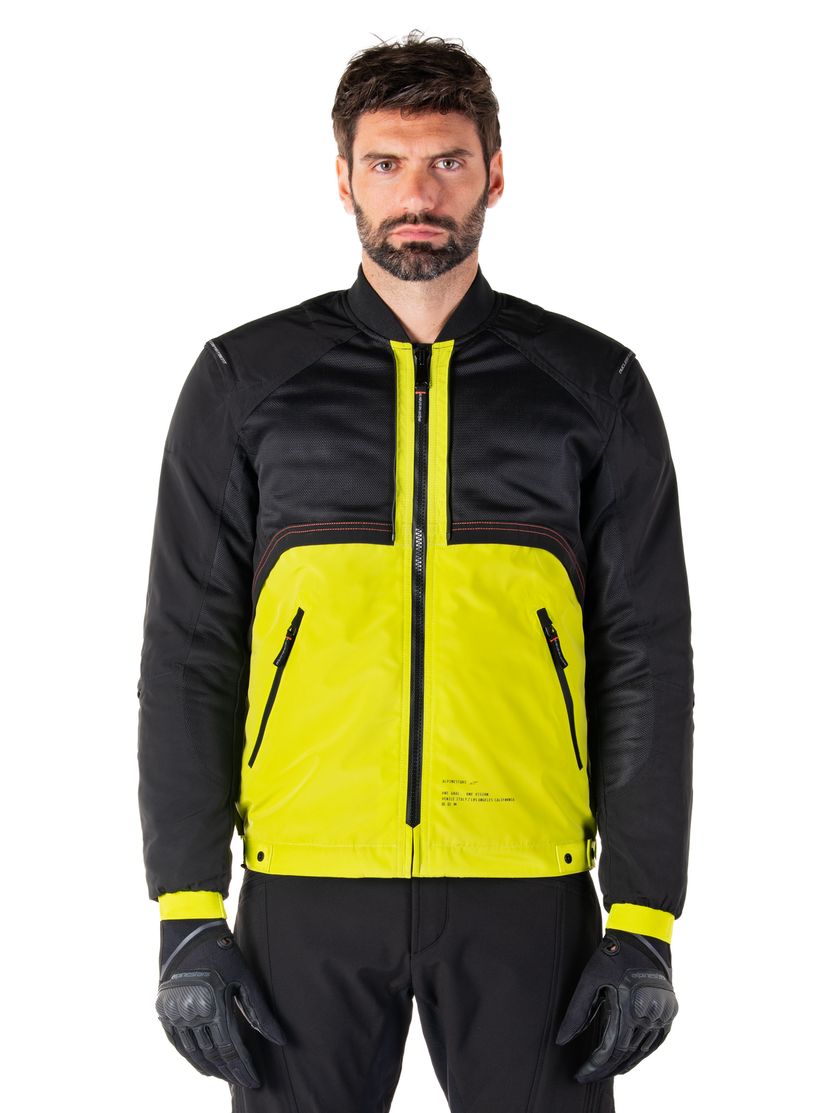 Mootant Waterproof Parka, modulare Motorradjacke, Lime Punch und Schwarz, getragen von einem männlichen Model mit schwarzen Handschuhen und Hosen, mit einem leuchtend gelben Unterkörper und schwarzem Oberkörper sowie Ärmeln, utilitaristisches Design für das Fahren bei jedem Wetter.