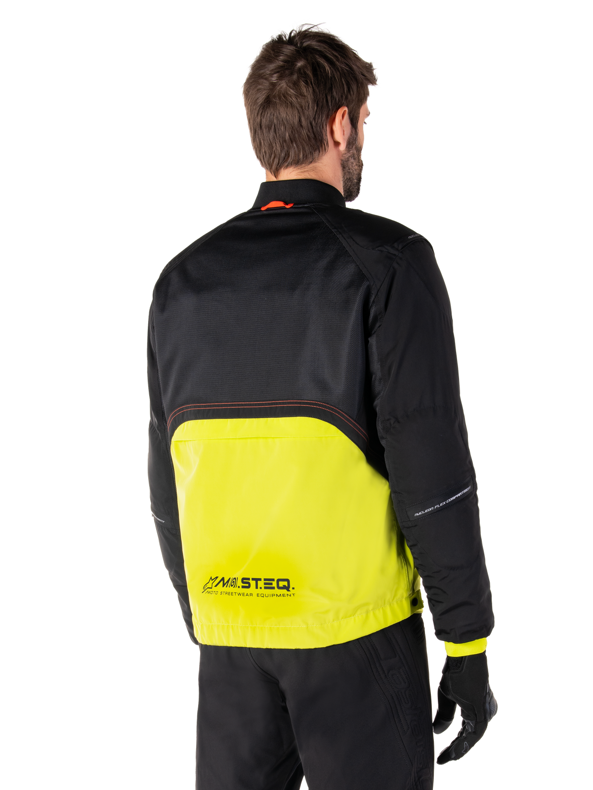 Alpinestars Mootant Wasserdichter Parka, Motorradjacke, Lime Punch und Schwarz, Rückansicht mit schwarzem Mesh-Gewebe oben und leuchtend limettengrünem unterem Bereich, mit MO.ST.EQ. Branding, getragen mit schwarzer Motorradhose und Handschuhen